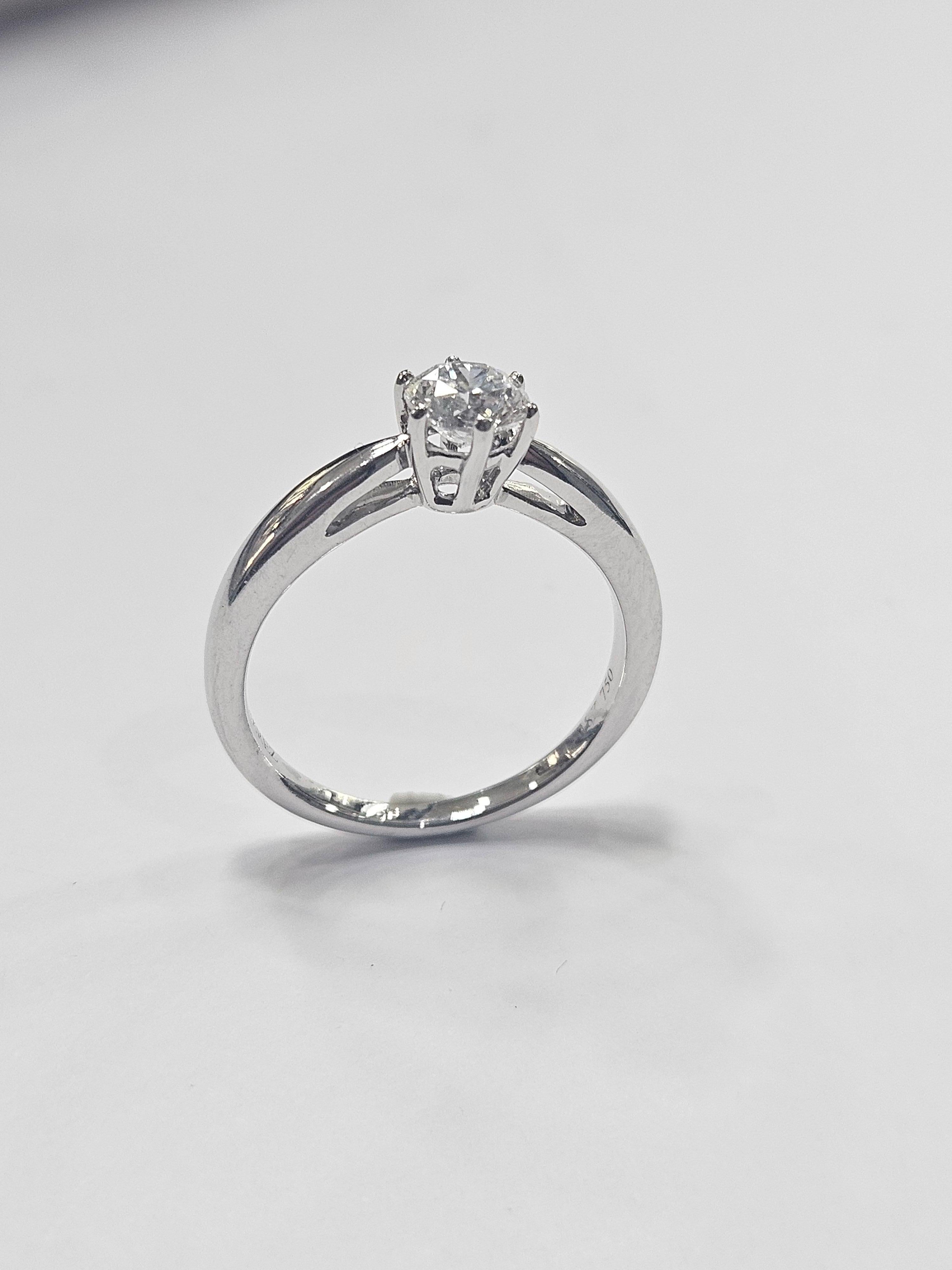 Traditioneller Solitär handgefertigt
in 18 Karat Weißgold, sehr massiver Sockel mit Galerie und Basis in abnehmendem Format, gefasst in 6 Zacken. Mit natürlichem Diamanten im Brillantschliff, 0,50 ct, (4,93-4,98 x 3,2 mm) Farbe D-E und Reinheit
