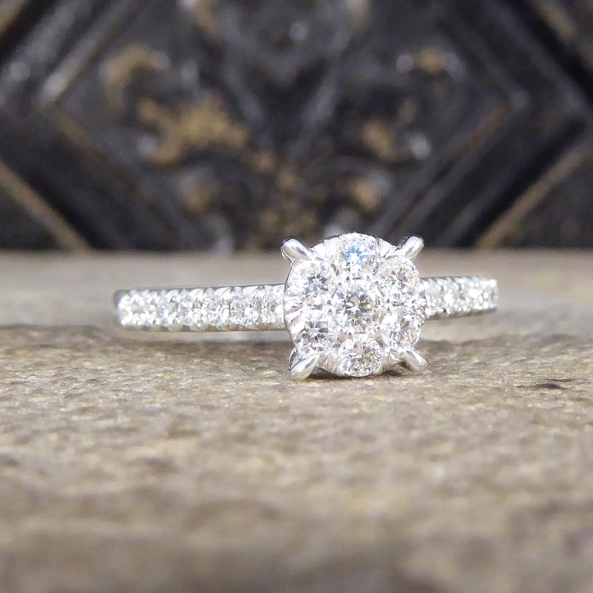 Ein wunderschön leuchtender und funkelnder Diamantring. Dieser Ring wurde so entworfen, dass er die Illusion eines größeren 1-karätigen Diamant-Solitärs in einer spitzen Vier-Krallen-Fassung vermittelt. Er besteht aus 7 gleich großen Diamanten mit