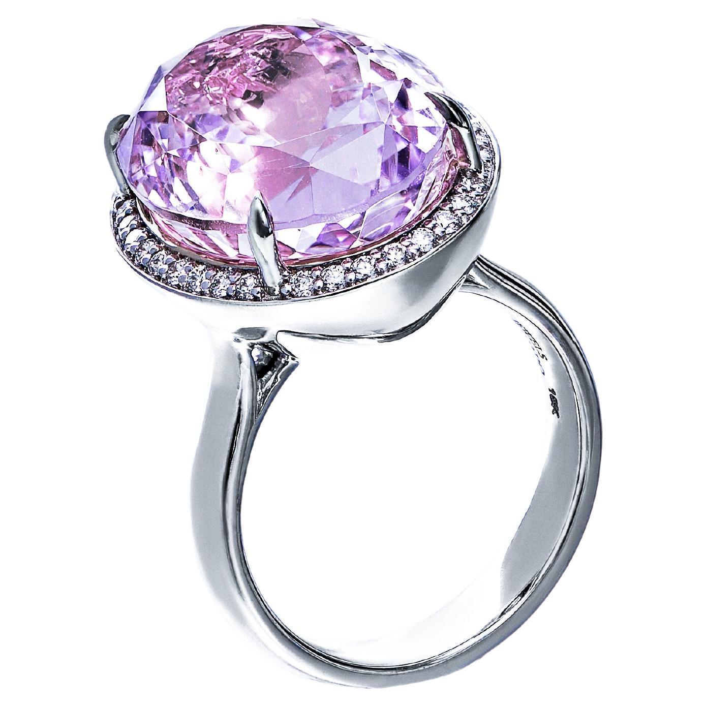 Introducing our mesmerizing Solitaire Kunzite Diamond Halo Ring, a stunning symbol of elegance and grace. This exquisite ring features a captivating oval-cut Kunzite stone, surrounded by a halo of small diamonds, all set on a combination of 18-karat