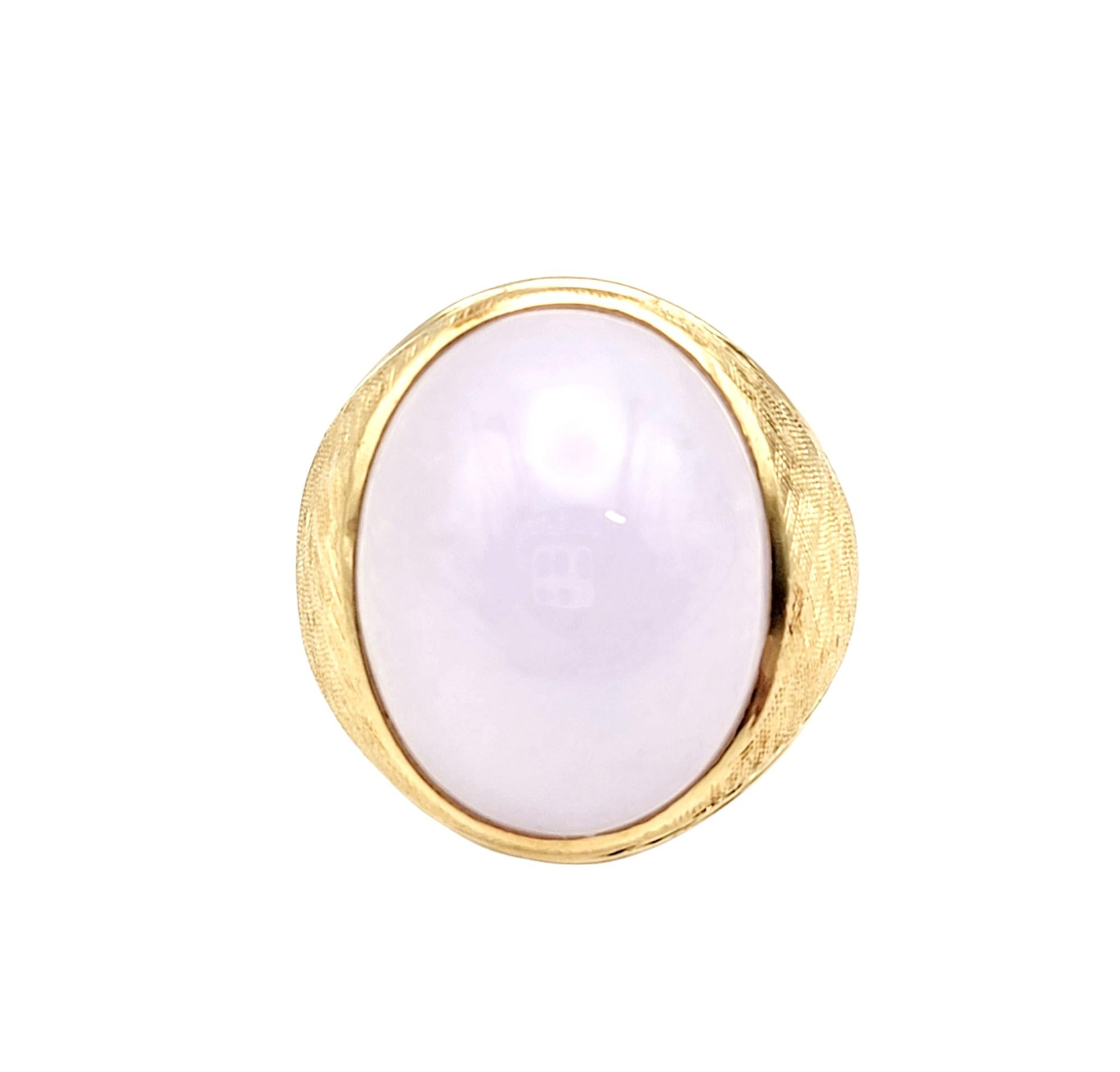 Ring size: 9

This bold and beautiful brushed and polished 14 karat yellow gold and lavender Jadeite cocktail ring is substantial in size and offers a subtle pop of color as it fills the finger.  

Ring Style: Solitaire
Metal: 14 Yellow Gold
Ring