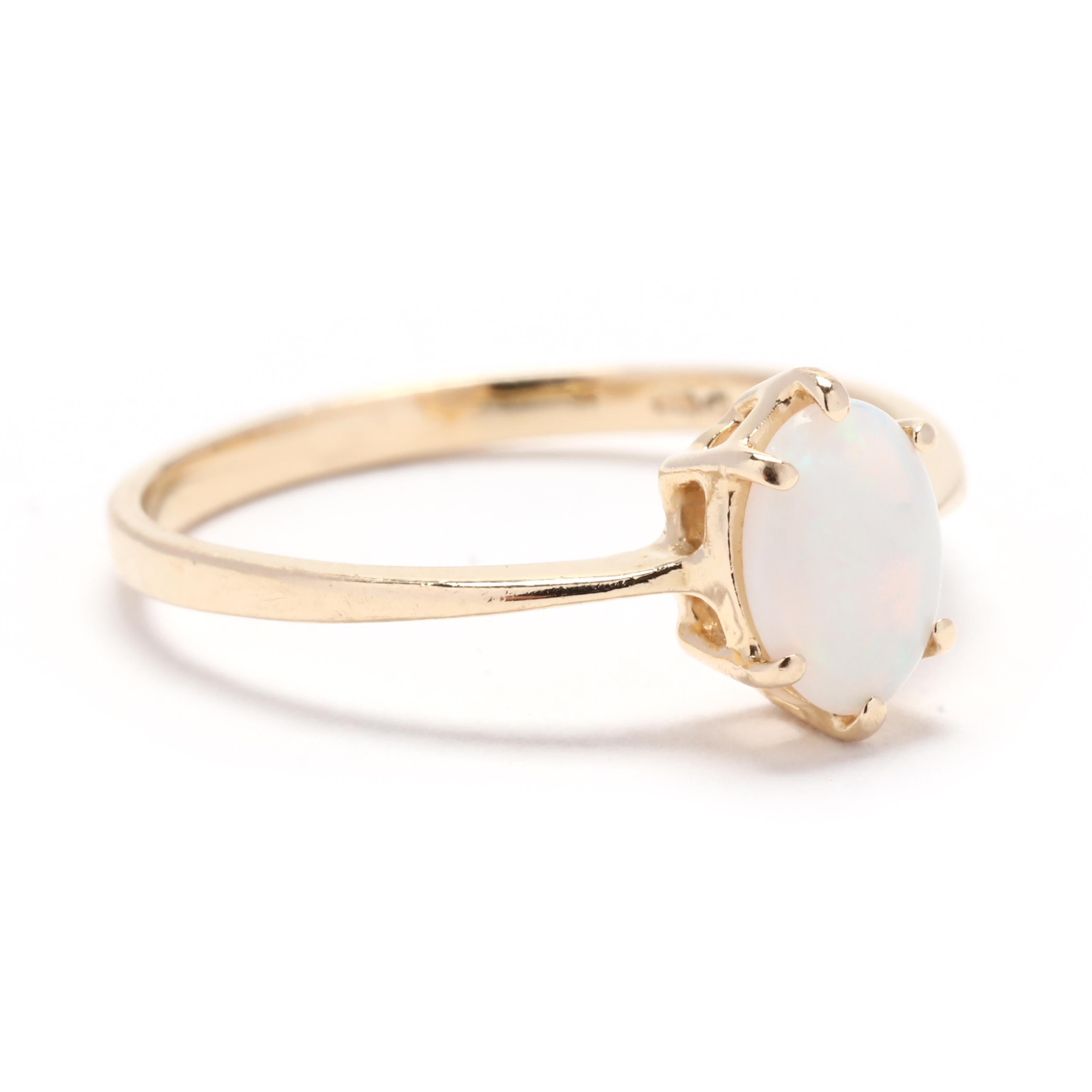 This stunning solitaire oval opal ring is the perfect accessory for any occasion. Crafted in solid 14K yellow gold, this ring is a timeless piece that will never go out of style. The centerpiece of this ring is a beautiful oval opal gemstone, known