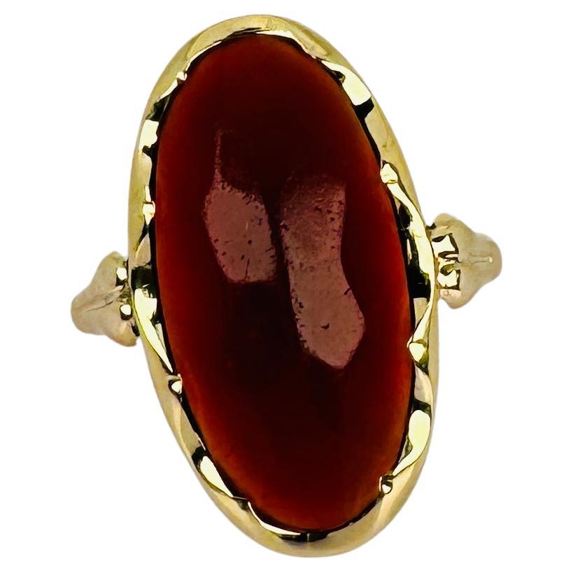Admirez la couleur et la forme captivantes de la pierre précieuse de cette bague en or jaune d'occasion. La coupe ovale et la chaude teinte orangée font de cette pièce un véritable régal pour les yeux. La pierre précieuse est sertie dans un écrin