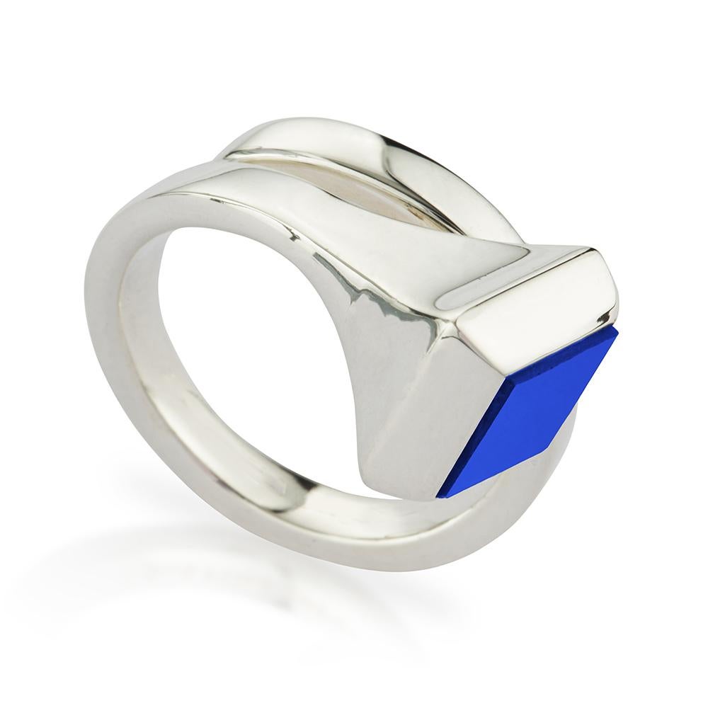 Unisex-Ring aus poliertem Sterlingsilber, besetzt mit Lapislazuli. Er ist so geformt, dass er sich organisch um den Finger dreht. Das Design ist von der Welt des Pferdesports inspiriert, da es an einen gedrehten Hufeisennagel erinnert,  und durch