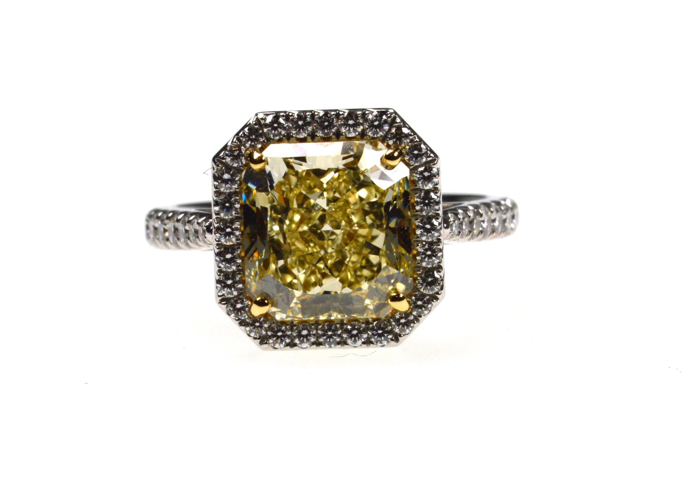 Solitaire Ring with a Radiant Cut Diamond Fancy Yellow of 4.05ct Clarity VVS2, surrounded by 54 round white diamonds of total 0.74ct. In 18K yellow gold and platinum 950.
Fancy Yellow Diamond comes with a GIA certificate 1152726778

Ring Size US 6.5
