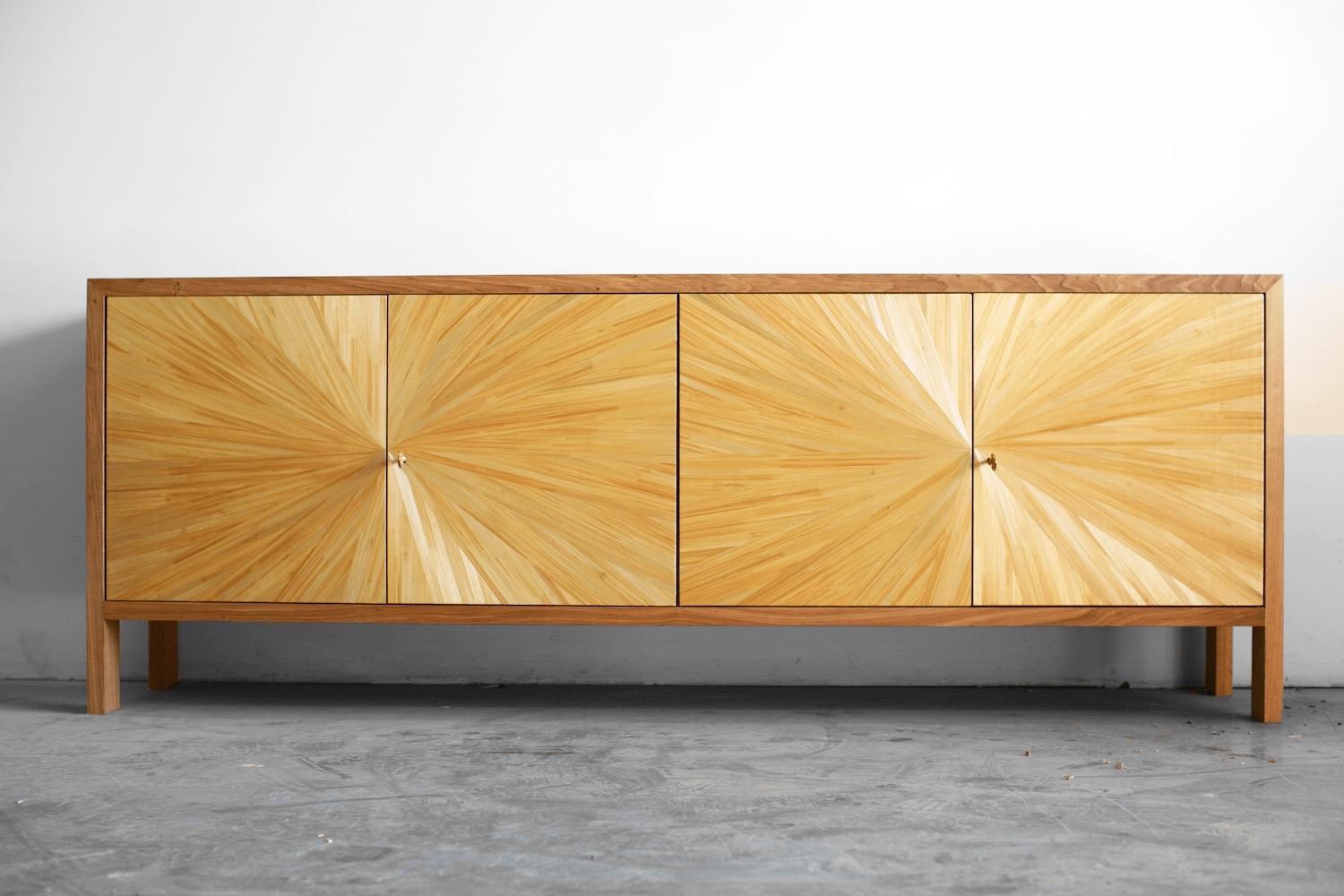 The Solstice buffet sideboard, featuring a sleek and minimalist design, has been crafted completely by hand and draws its inspiration from the village of Saint-Tropez. The warmth of the light oak wood and the shimmering chatoyance of the straw