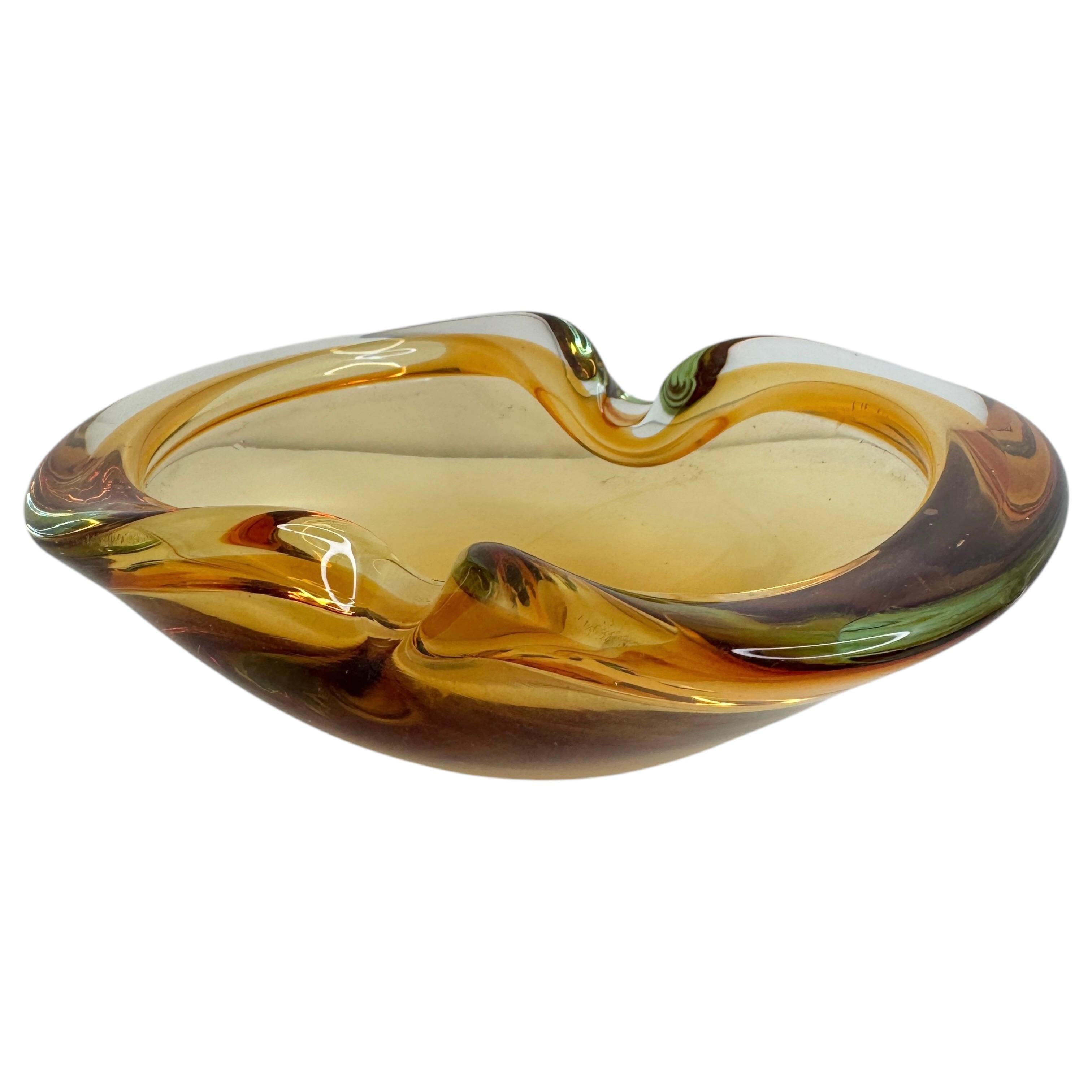 Magnifique verre d'art de Murano du milieu du siècle avec d'étonnantes nuances de couleurs allant de l'ambre au vert clair en passant par le transparent. Cette pièce a été produite en Italie dans les années 1970 ou plus anciennement.
Cette