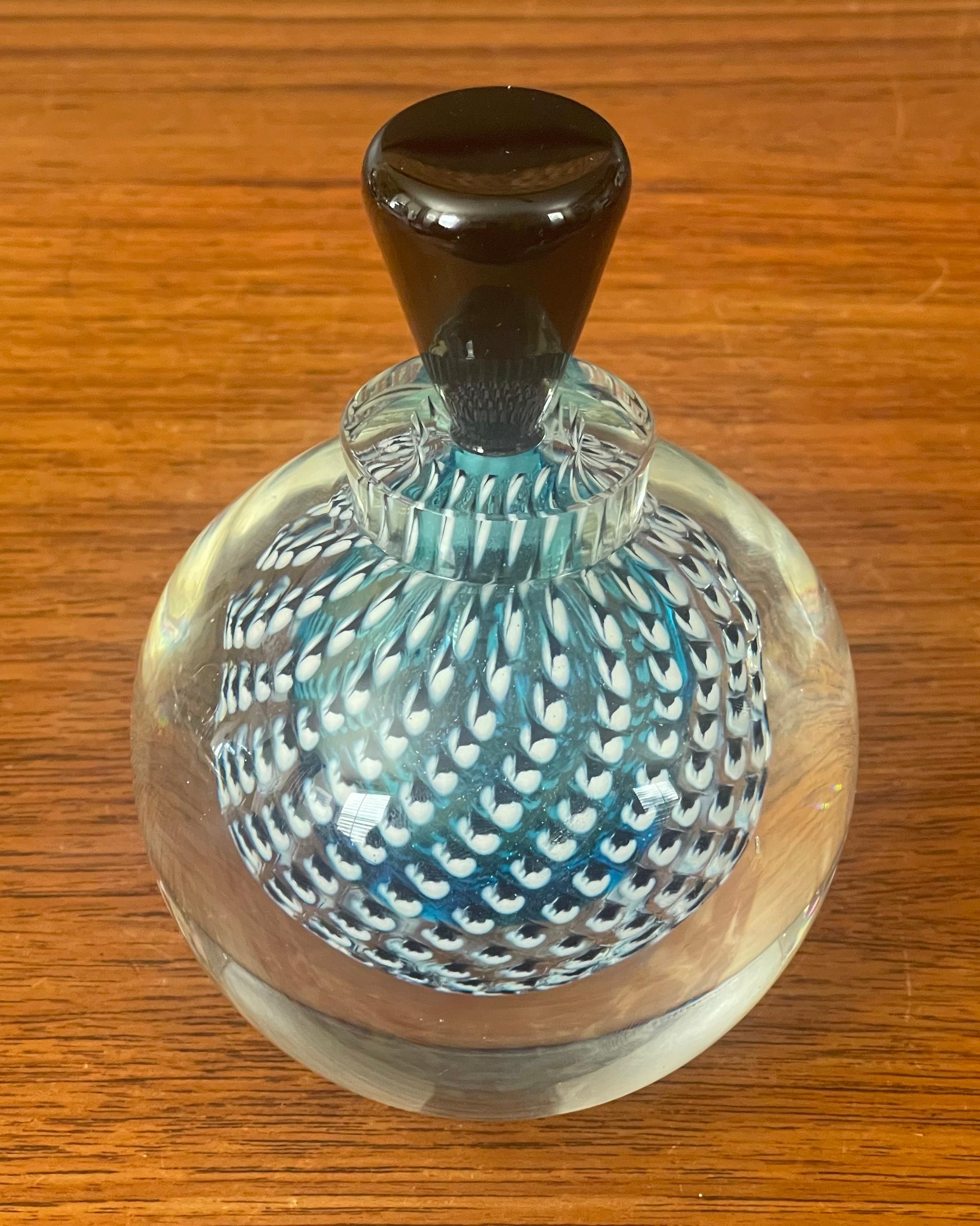 Stunning sommerso art glass perfume bottle with stopper by Steven Correia, circa 1994. This piece is absolutely gorgeous with an inner orb of blue glass with rows of black and white dots surrounded by a thick outer layer of clear glass and a black
