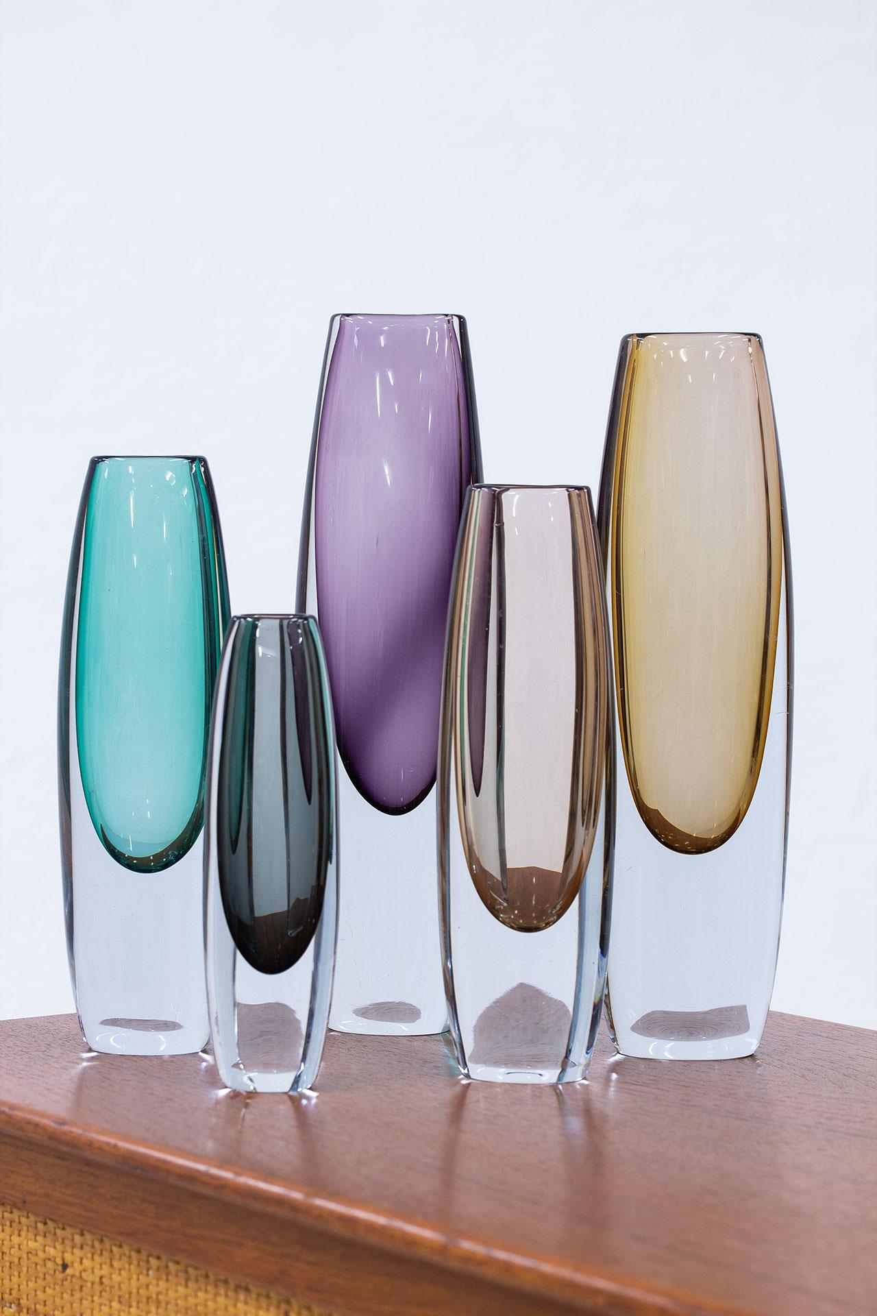 Group of 5 “sommerso” type vases. Designed by Gunnar Nylund and Asta Strömberg. Manufactured by Strömbergshyttan in Sweden during the 1950s. Colored glass cased in clear glass technique. Three of the vases are signed (engraved on the bottom).
The
