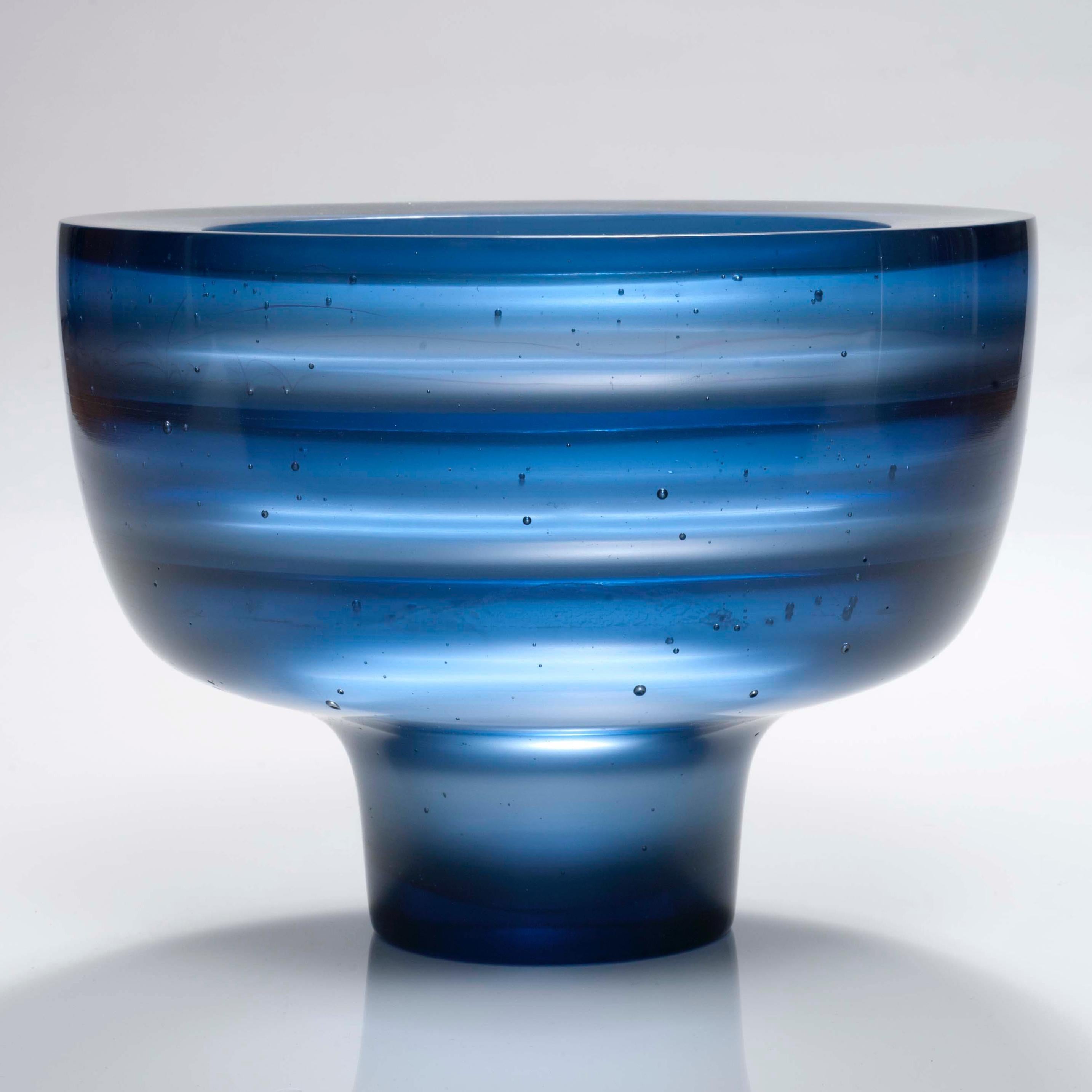 Somu is a cast glass artwork in a beautiful soft steel blue by the British artist Paul Stopler. With a smooth exterior, the interior is stepped into four sections by three ridged protruding 