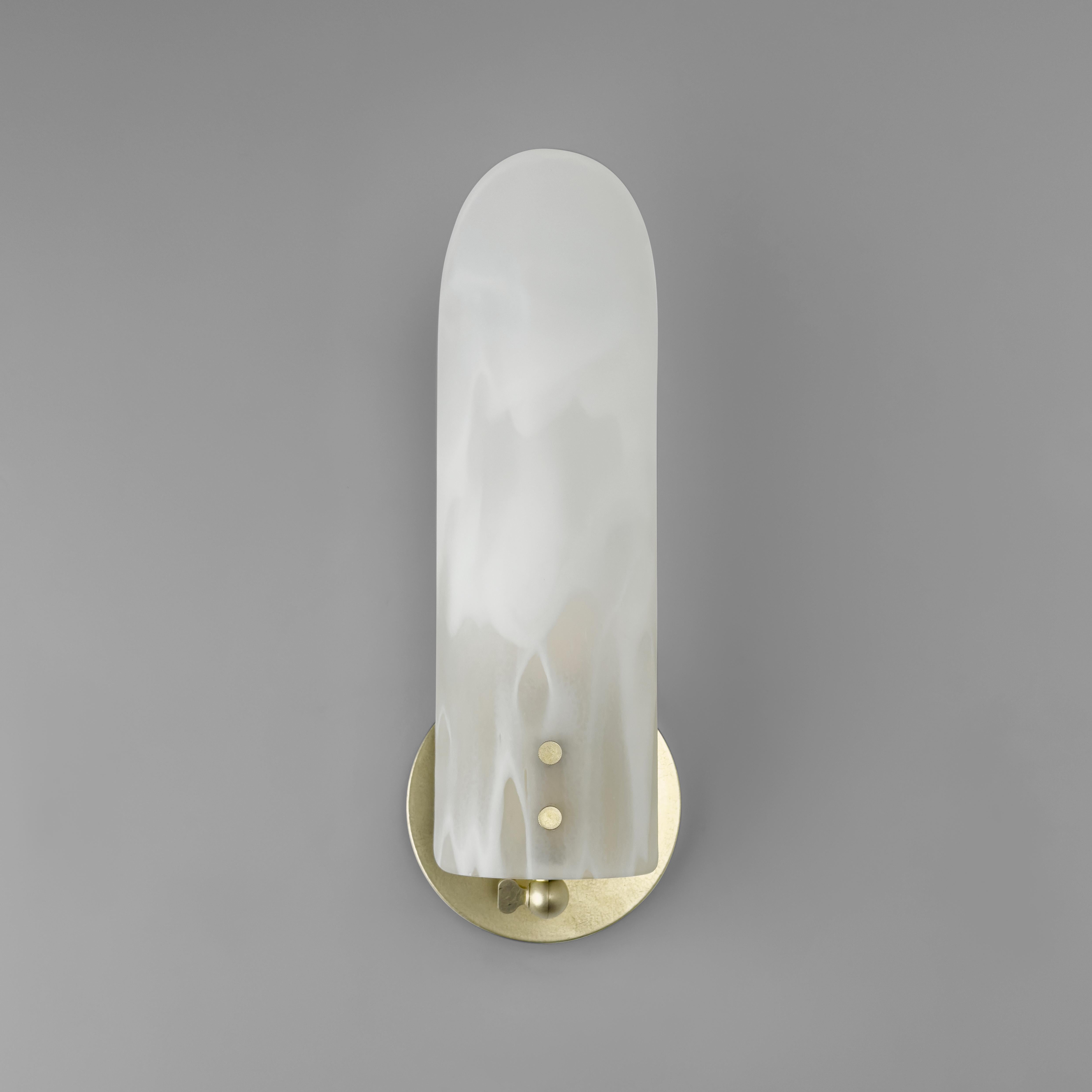 La Lámpara Sonata mostrada en acabado (Latón encerado) y pantalla de cristal (Nube), es una versión simplificada de nuestra Lámpara Sonata Tipo 1, la Lámpara Sonata aporta elegancia y flexibilidad a cualquier espacio. Con un diseño ajustable, este