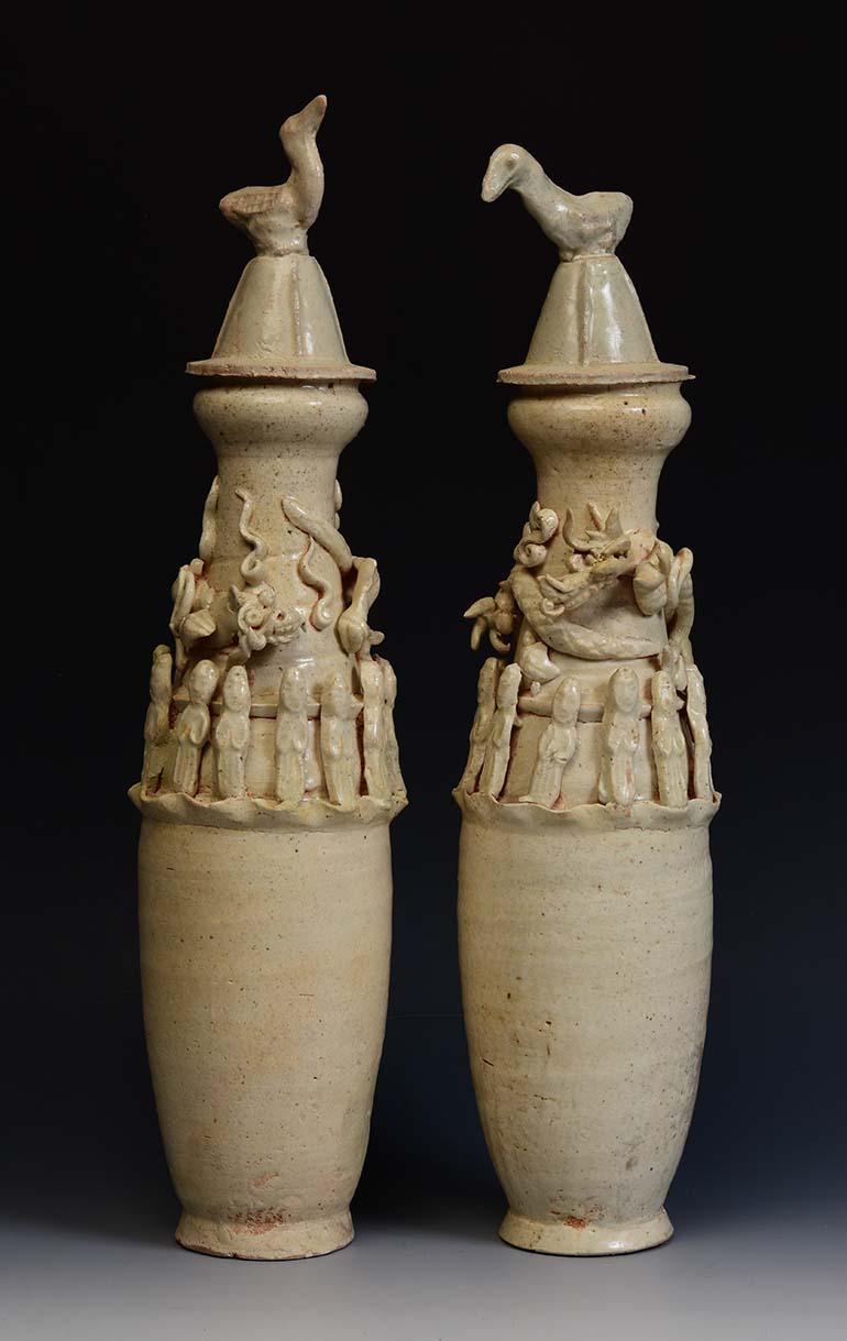 Zwei antike olivgrüne Porzellanvasen aus der Song-Dynastie, dekoriert mit Göttern um die Vase und einem fliegenden Drachen auf der Oberseite jeder Vase. Jeder Deckel ist oben mit einem Kranich verziert.

Alter: China, Song-Dynastie, 10. bis 13.