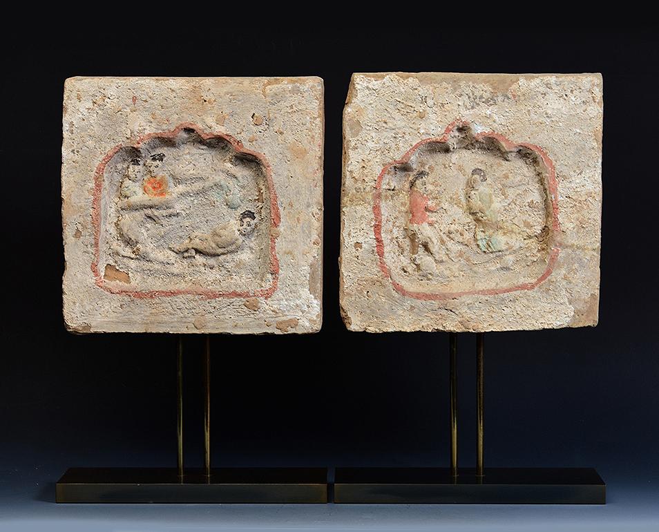 A pair of antique Chinese pottery brick tile with figures.

Age: China, Song Dynasty, 10th - 12th century
Size excluding stand: Height 26.5 C.M. / Width 26.5 - 26.8 C.M.
Height including stand: 44 C.M.
Condition: Well-preserved old burial condition