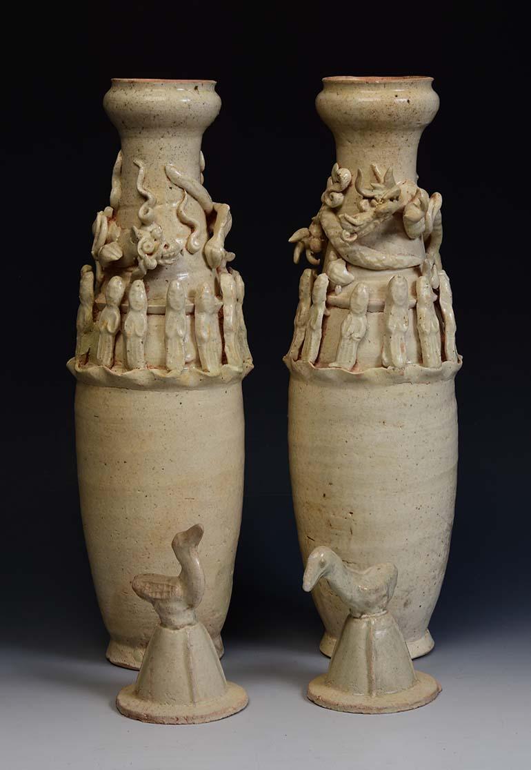 Ein Paar olivgrüne Porzellanvasen aus der Song-Dynastie, verziert mit Göttern um die Vase und einem fliegenden Drachen auf der Oberseite jeder Vase. Jeder Deckel ist oben mit einem Kranich verziert.

Alter: China, Song-Dynastie, 10.-13.