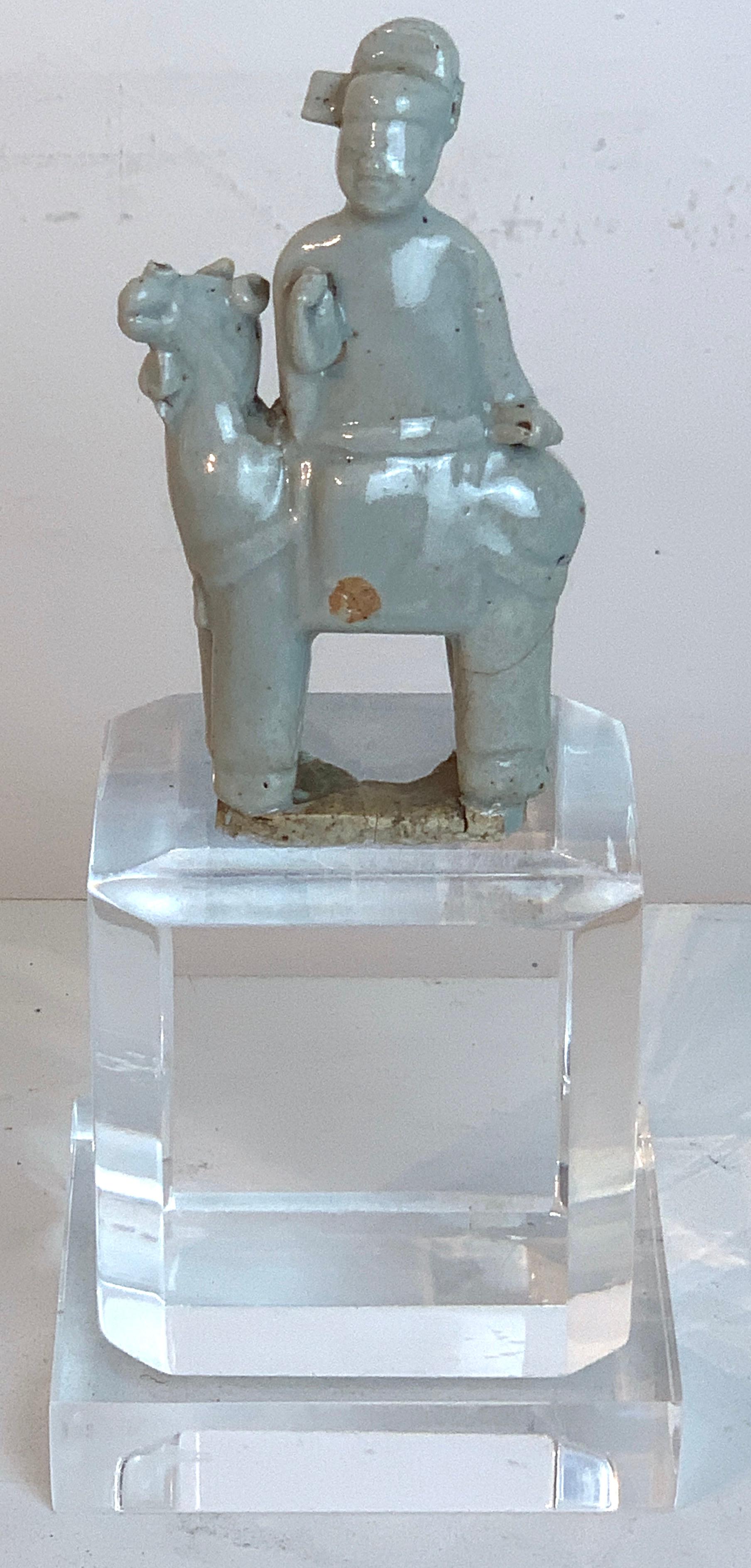 Cheval et cavalier en porcelaine céladon chinoise de la dynastie Song sur un piédestal en lucite plus tardif
Cheval et cavalier chinois en porcelaine céladon, probablement de la dynastie Song (10e-13e siècle ADS)
La figurine seule mesure 2