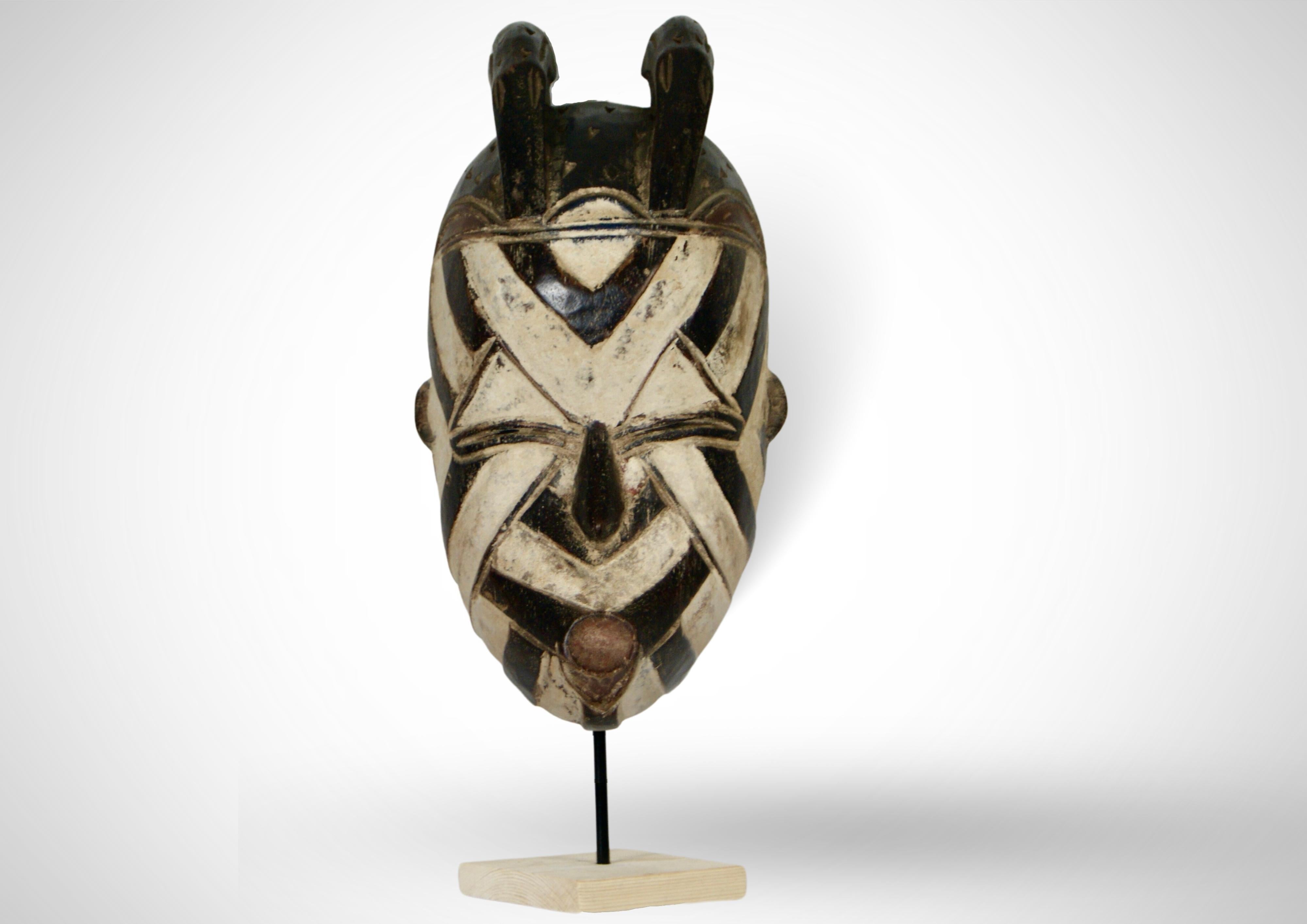 Nous vous proposons un masque Basangwe du peuple Songye de la République démocratique du Congo, datant des années 1950.
 
Le masque présente la forme faciale typique des masques Basangwe.
Au sommet, elle présente une paire d'oiseaux stylisés décorés
