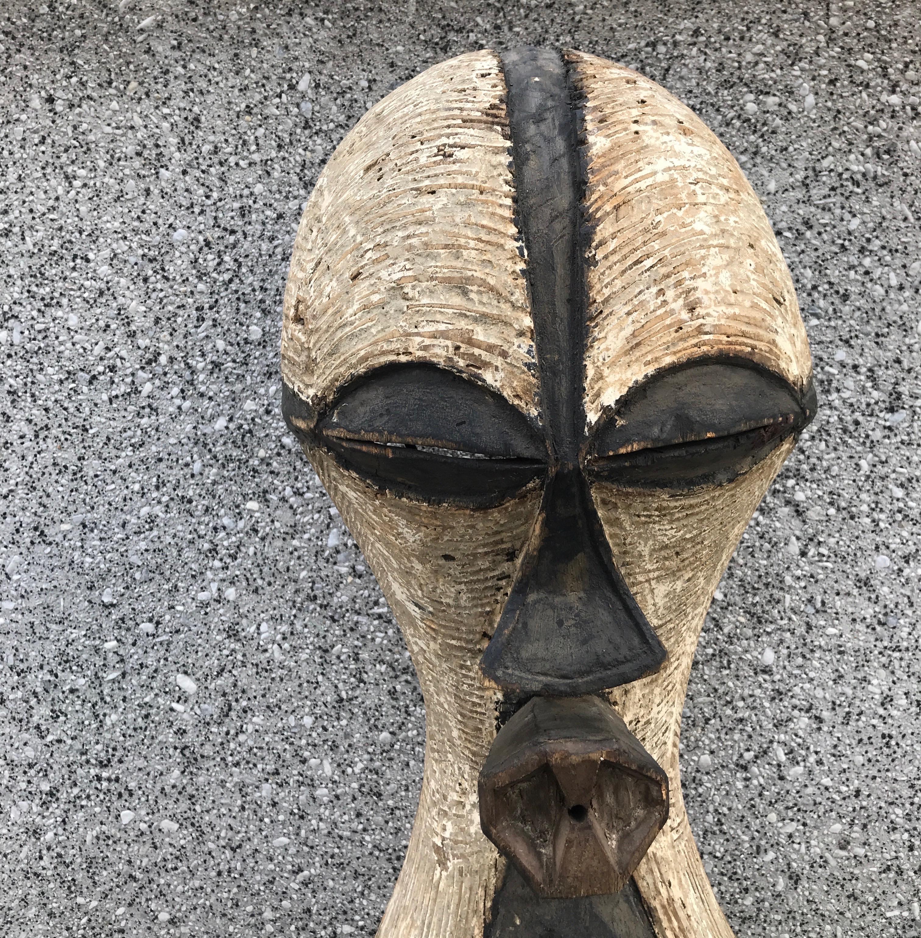 A large, masterfully hand carved female dance mask (kifwebe) in the style of the Songye people of the Congo. This striking piece features a weathered surface , exhibiting a beautiful patina. Mounted on a custom made stand. Can also be mounted