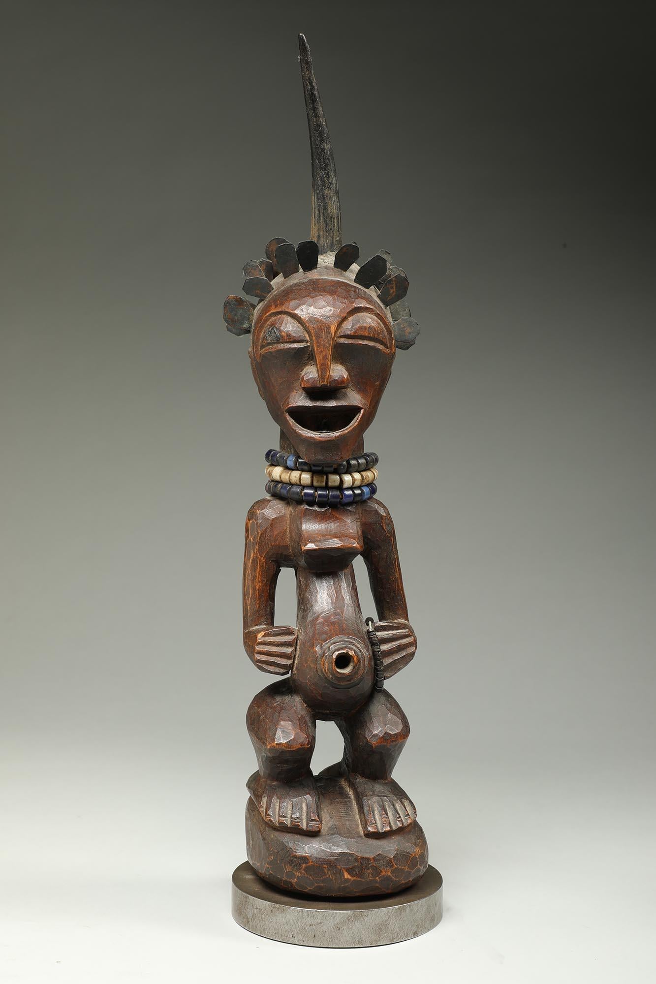 Hand-Carved Songye Female Wood Figure with horn and brass hair ex Sothebys   For Sale