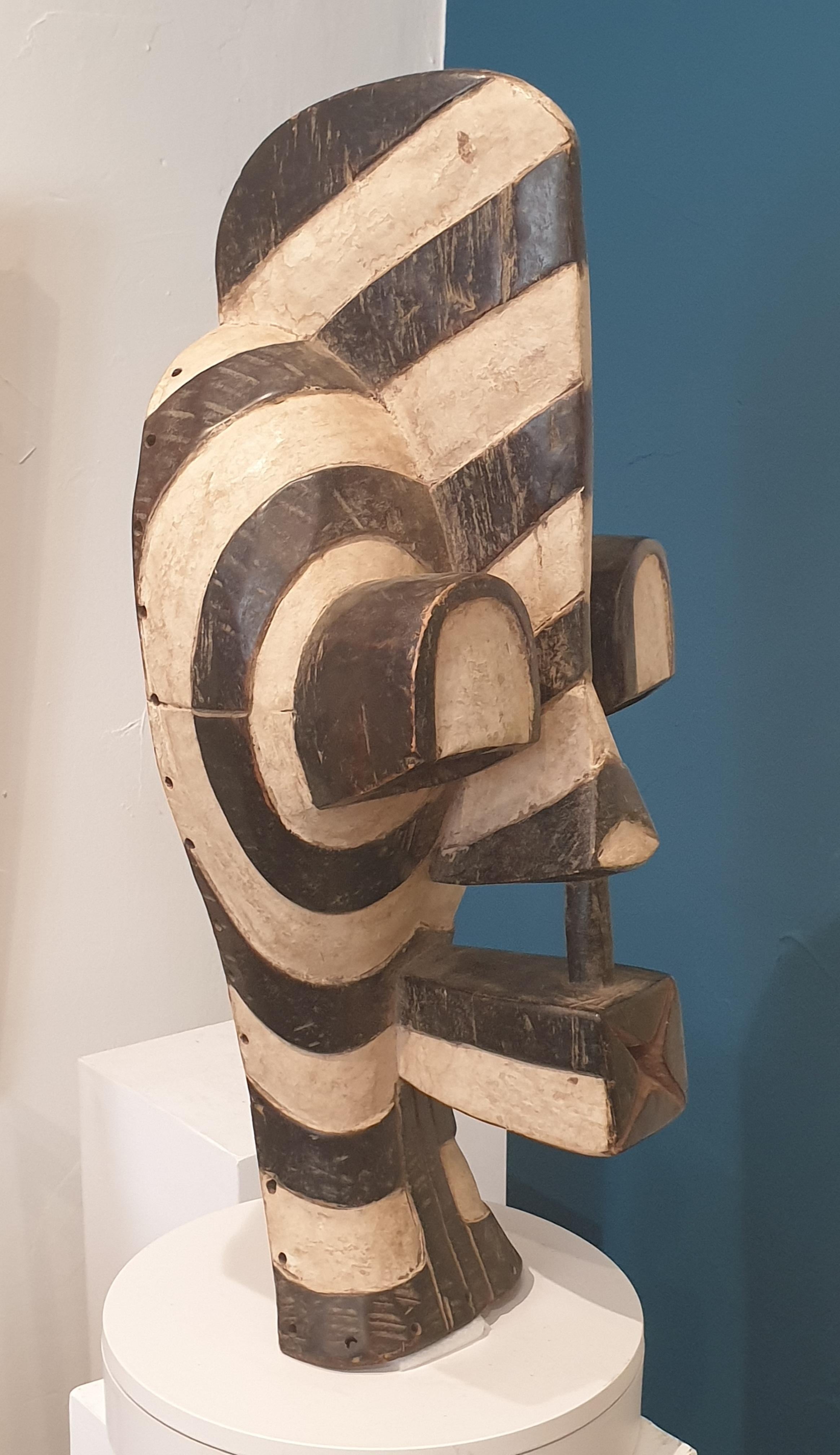 A fine large Songwe Kifwebe or mask from the Democratic Republic of Congo, of typical exaggerated form; the mask with high sweeping crest, long projecting eyes and forward thrusting nose and mouth; the whole incised with linear striations with dark