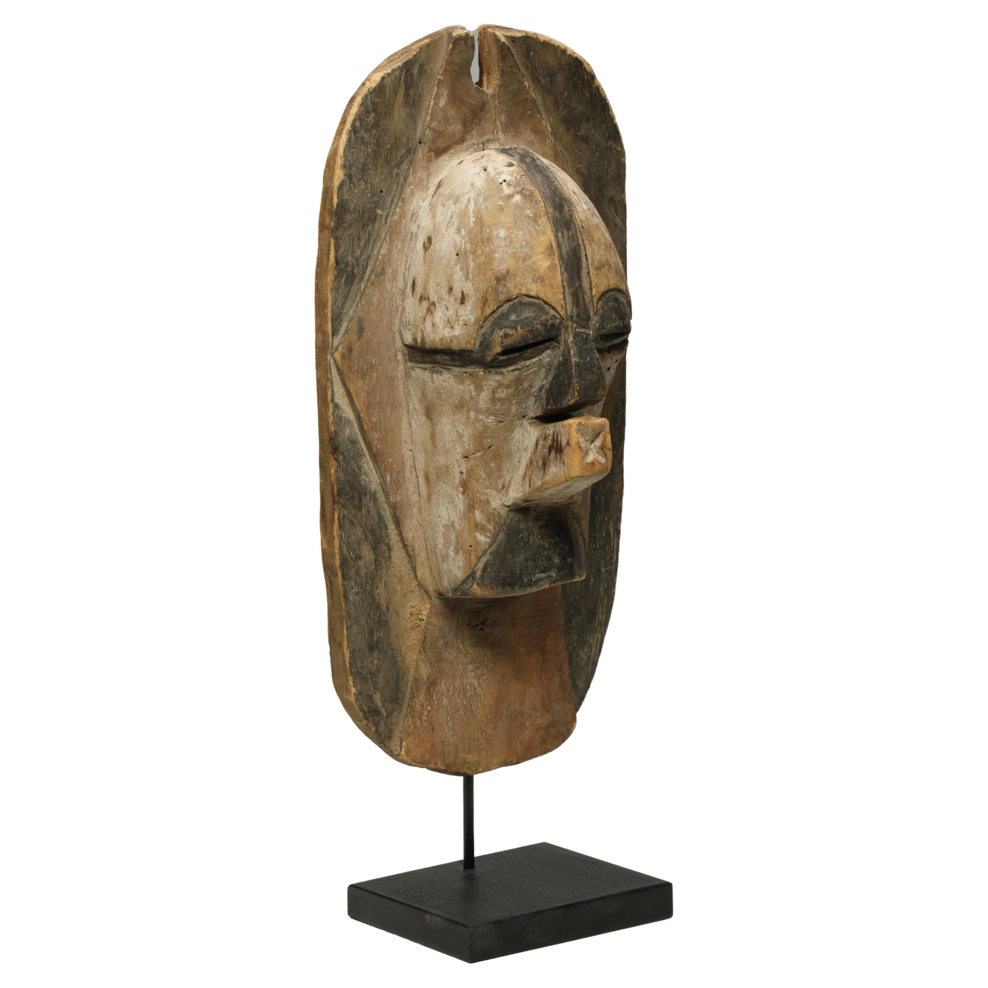 Songye or luba kifwebe wood mask or shield, designed to be hung on the wall, with traces of white, red and black pigments. Africa, Congo

This mid-20th Century mask shows great design, color and character from age and use. Projecting nose and mouth