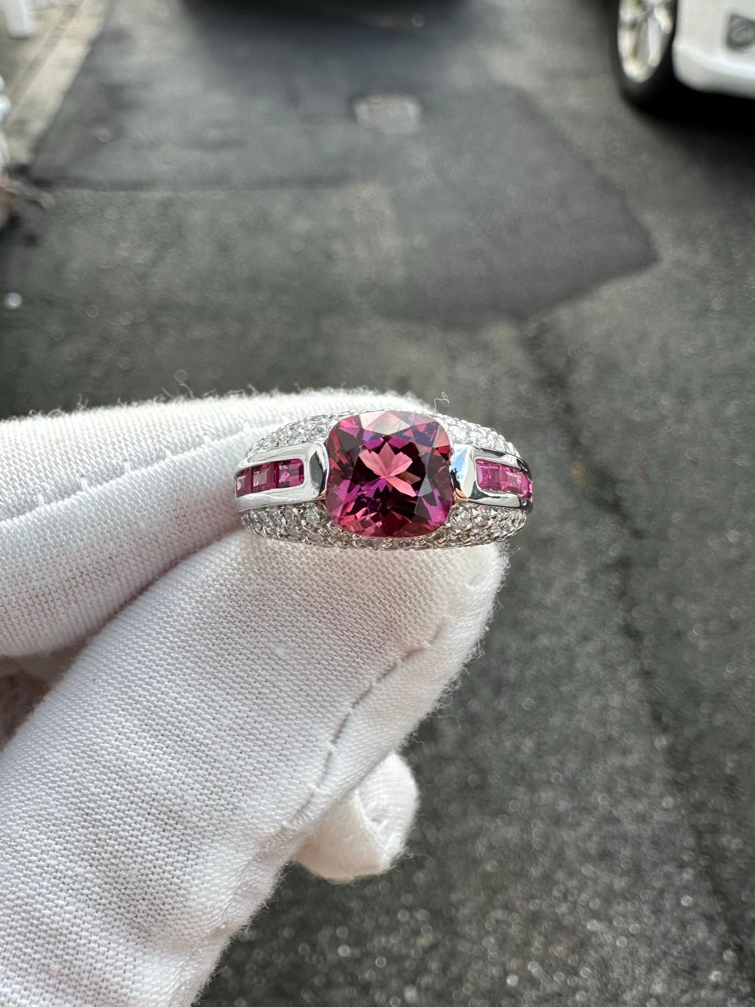 Here we have a very lovely tourmaline, spinel, and diamond cocktail ring that is designed by Sonia B. and crafted in solid 18k white gold. It features a fine quality, rich and vivid pink tourmaline solitaire neatly set at the center. The gorgeous