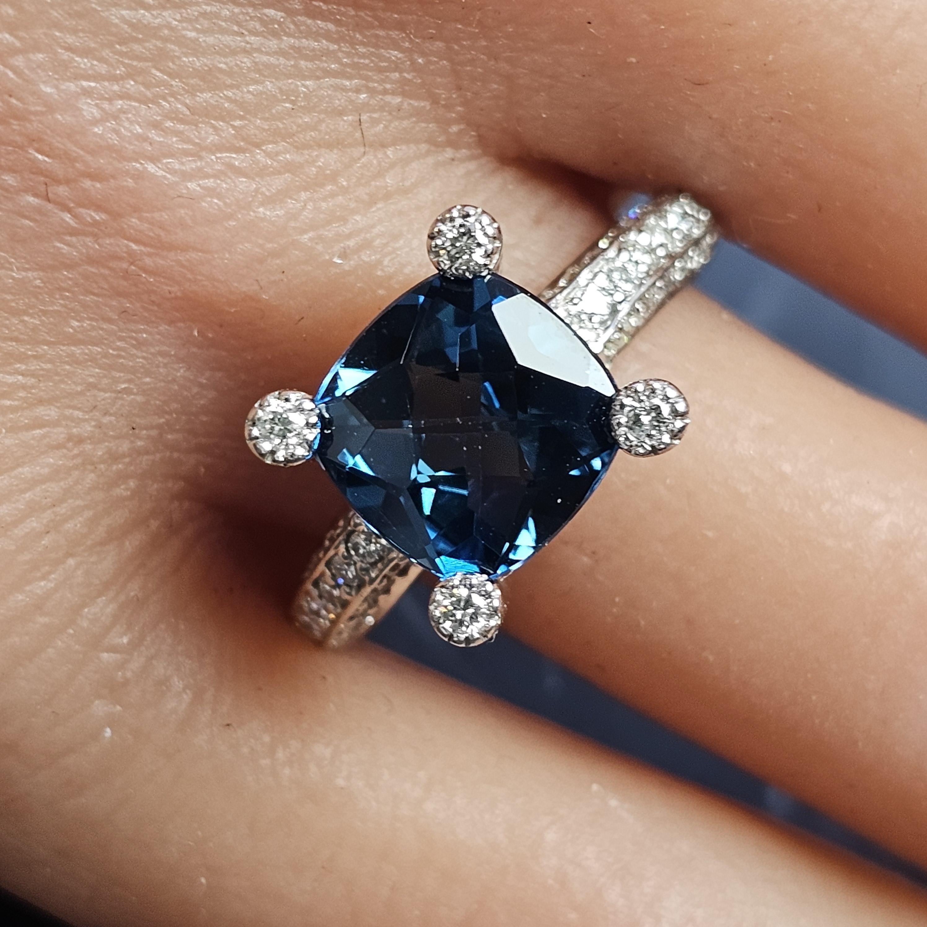 Here we have a Sonia B. Lodon Blue Topaz cushion cut center and Diamond ring in 14k white gold, size 8.

**Specifics**
- Measurements: Finger size 8 and measures 0.38 inches wide.
- Primary Stone: Blue Topaz, Cushion cut, Blue color
- Secondary