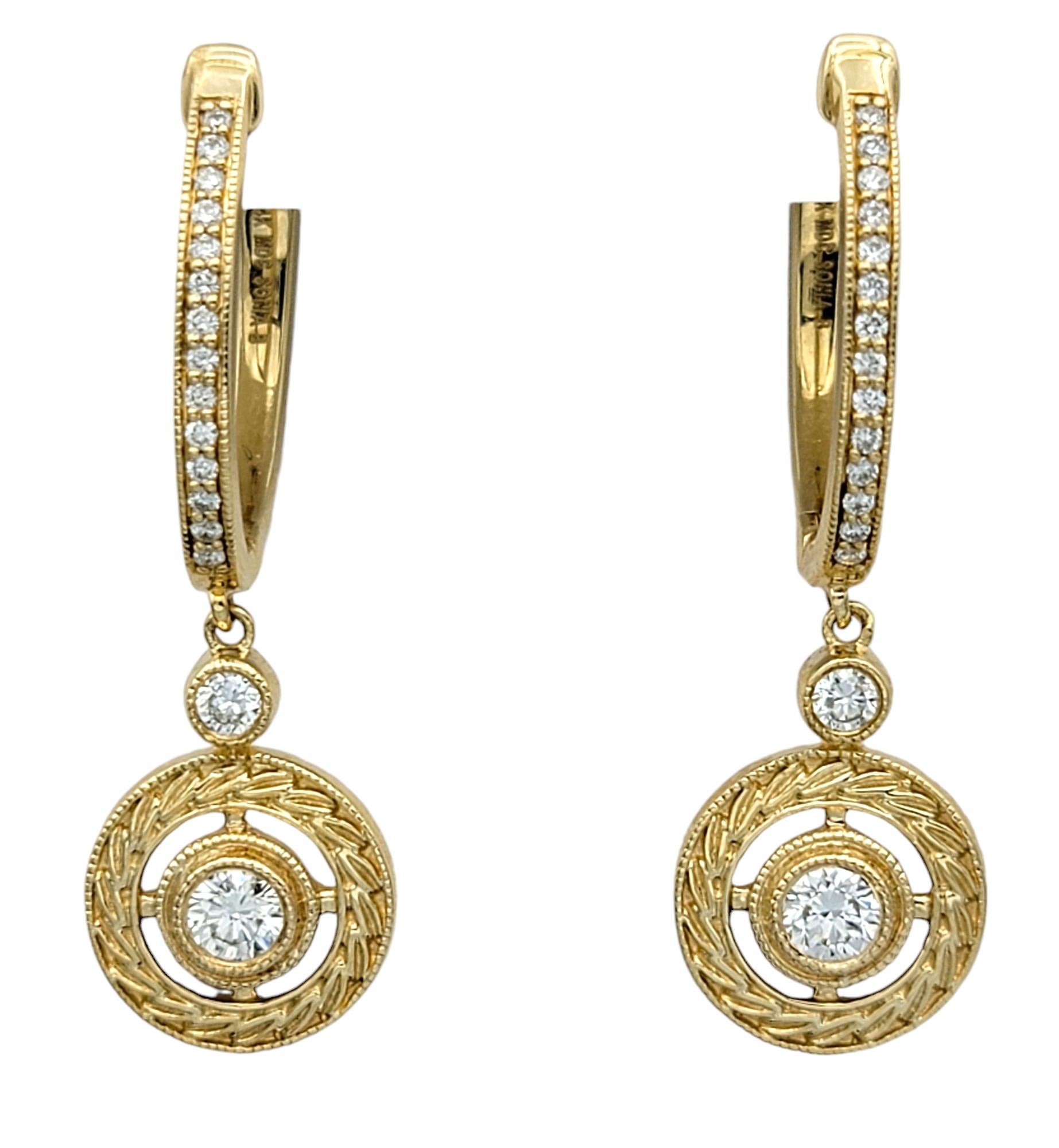 Añade un toque de elegancia y opulencia a tu colección con estos impresionantes pendientes de aro colgantes de Sonia B. Designs, exquisitamente elaborados en oro amarillo de 14 quilates. Cada pendiente presenta dos diamantes deslumbrantes,
