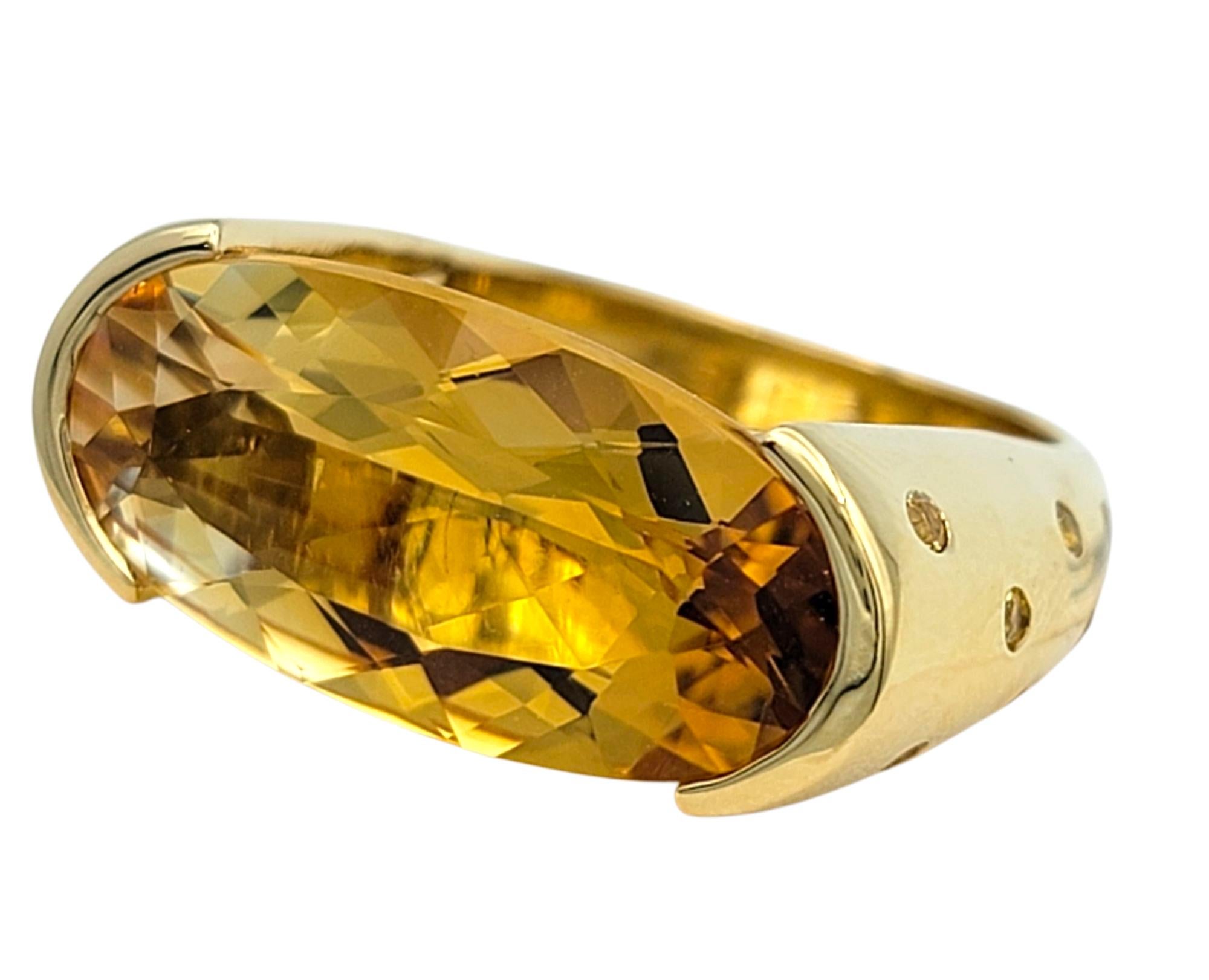 Misura dell'anello: 4,75

Questo audace anello da cocktail a forma di ponte di Sonia B. è caratterizzato da un sorprendente citrino incastonato a est-ovest in una calda tonalità dorata. Il citrino dal taglio ovale si trova al centro, con i suoi