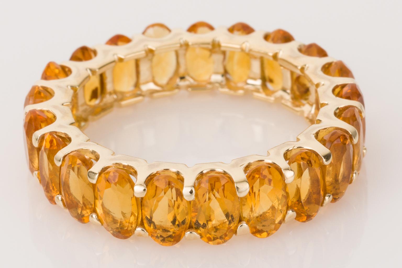 A really different look, a twist on the classic neverending eternity band ring, instead of diamonds why not have golden citrine all around your finger. 
Set in 14k yellow gold, these 20 oval cut faceted citrines look so bright and lively. Each