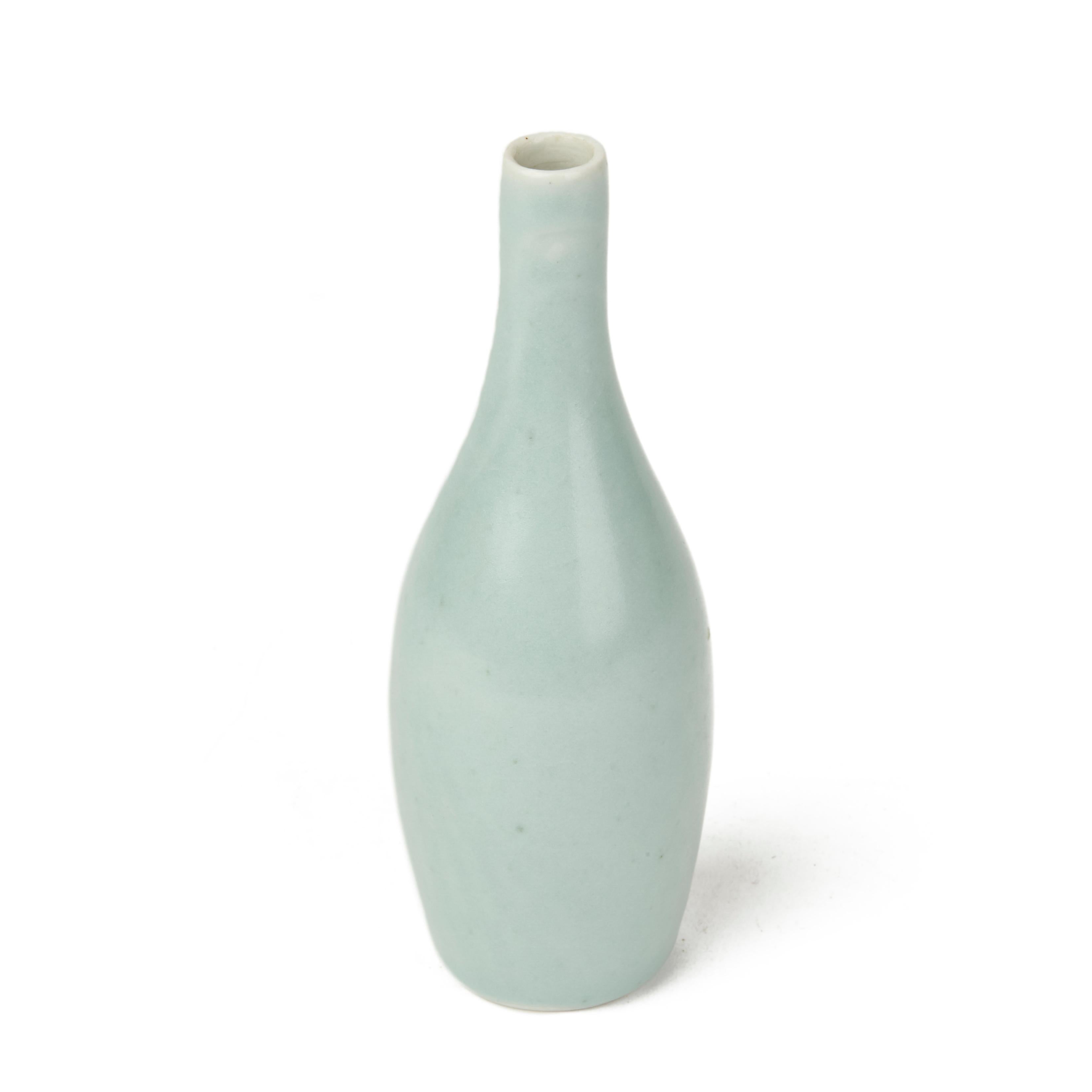 A stunning studio ceramic porcelain bottle shaped vase decorated in celadon green glazes by renowned Cambridgeshire based potter Sonia Lewis. This well potted vase stands on a rounded unglazed foot with an artists impressed mark to the base. Sonia