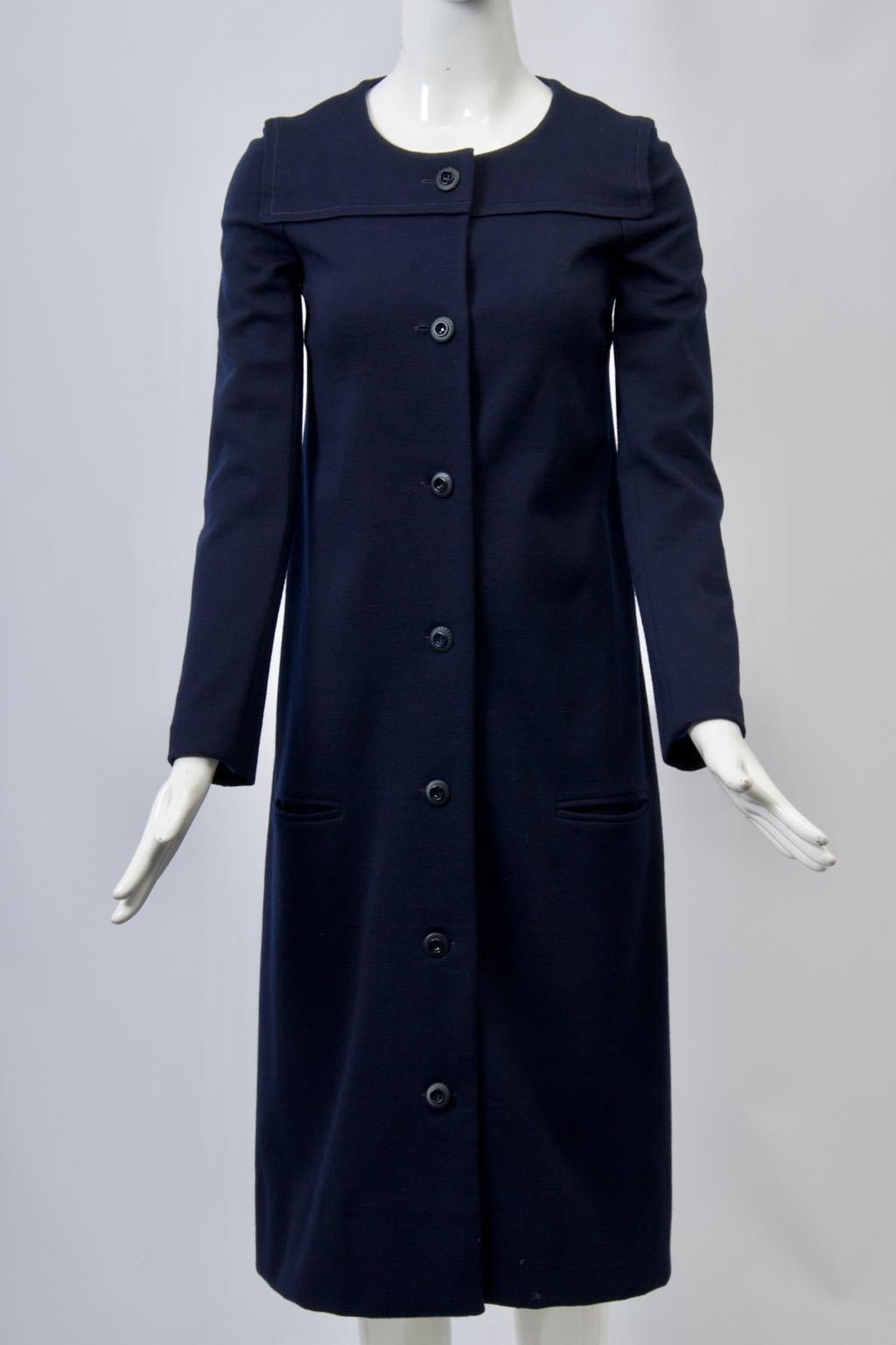 1970s dress and coat ensemble in navy wool knit by Sonia Rykiel. The slim coat features a top-stitched yolk detail, a round neckline, and single-breasted closure fully buttoned down the front. The long sleeve dress skims the body and has a