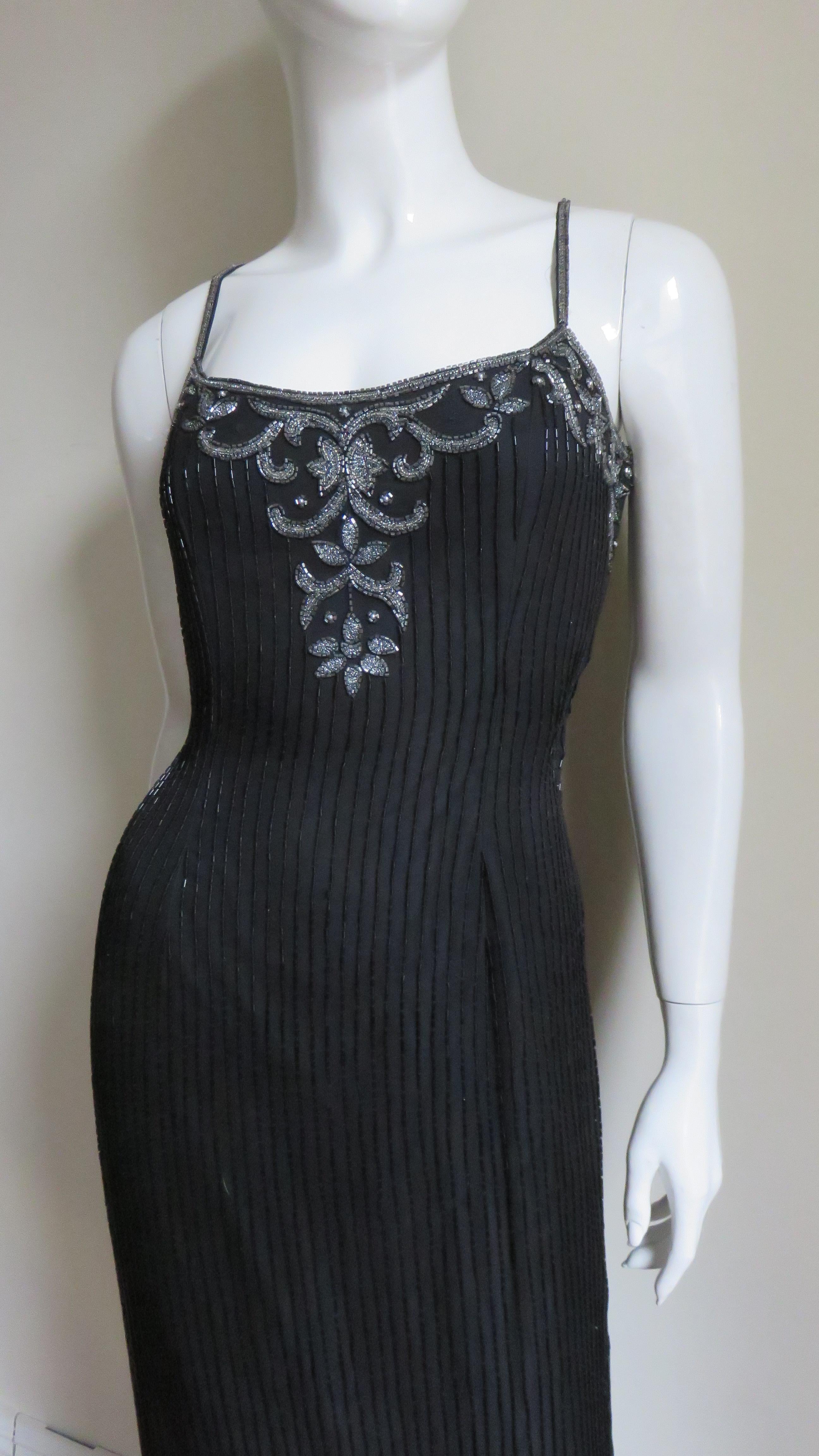 A beautiful full length beaded black silk gown from Sonia Rykiel. There are lines of tubular black glass beads the full length of the dress and the front bodice is accented with a silver beaded design which is also on the entire sheer to the waist