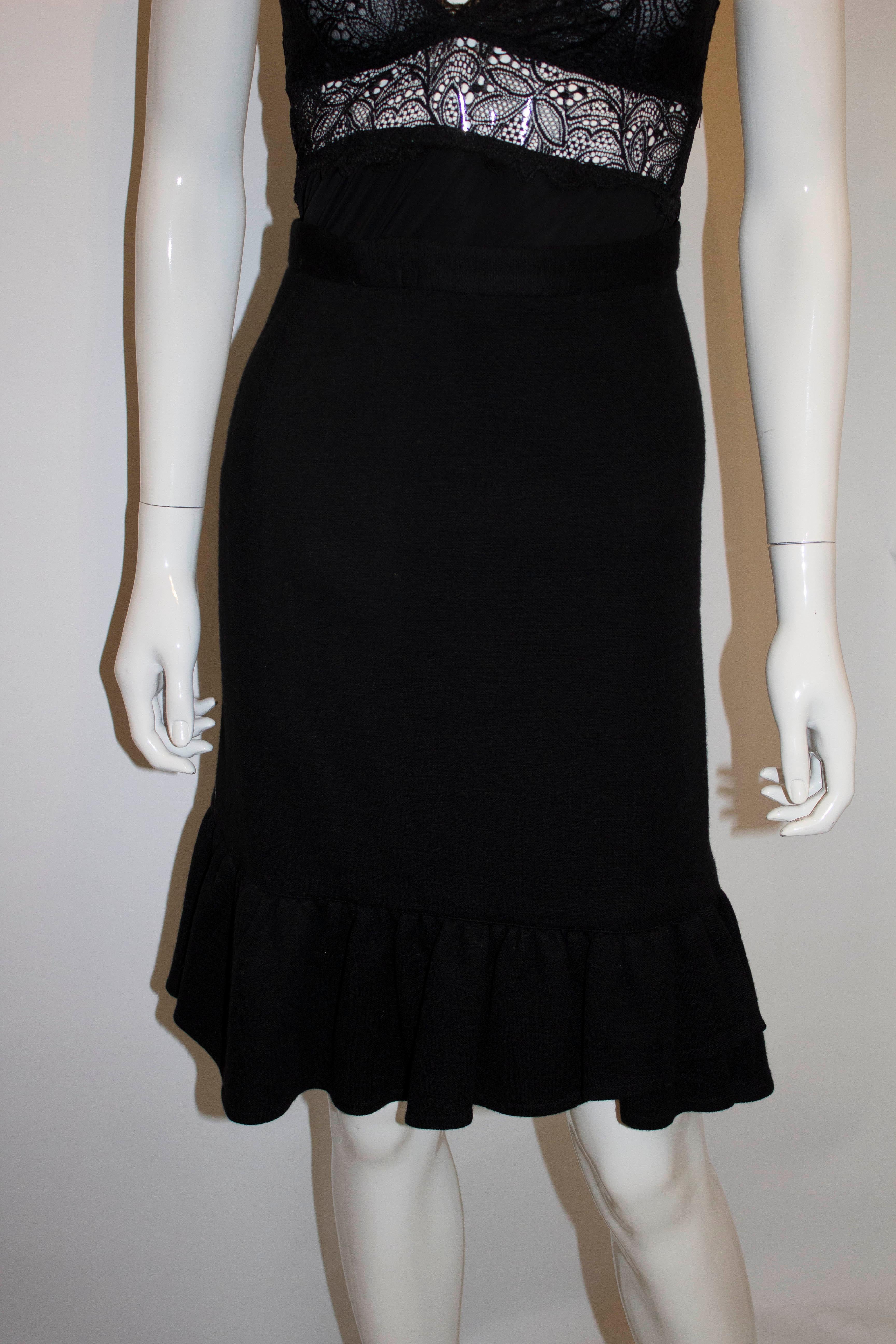 A fun and flirty black wool skirt by Sonia Rykiel, main line. The skirt has a side zip fastening, with interesting frill detail at the hem. It is unlined. Size 40, waist 26'' , length 23''