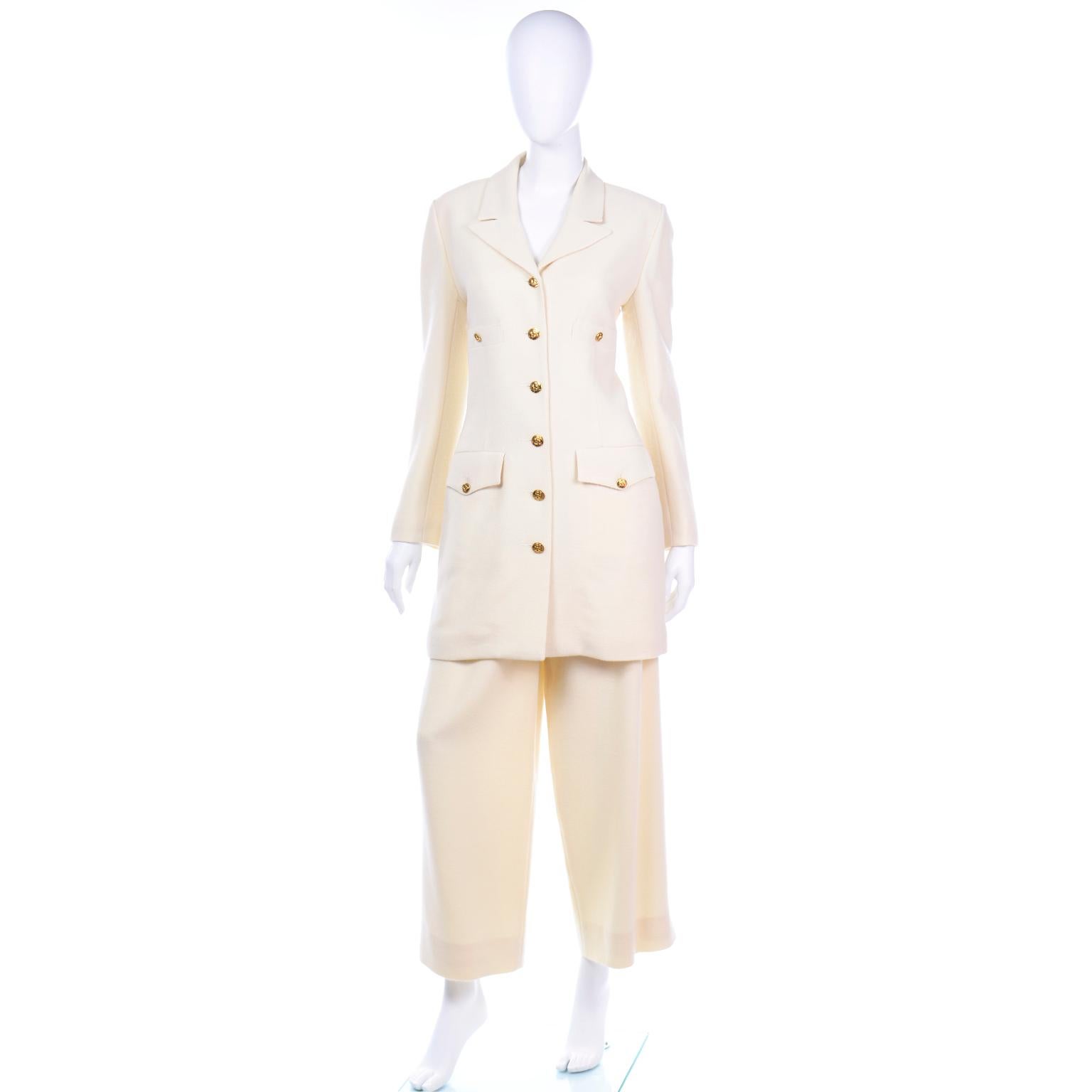 This is such a beautiful Sonia Rykiel creamy ivory textured wool suit with a long line blazer and pleated wide leg trousers. The longline jacket has two functional buttoned breasted pockets and two flap pockets. The front of the jacket is secured