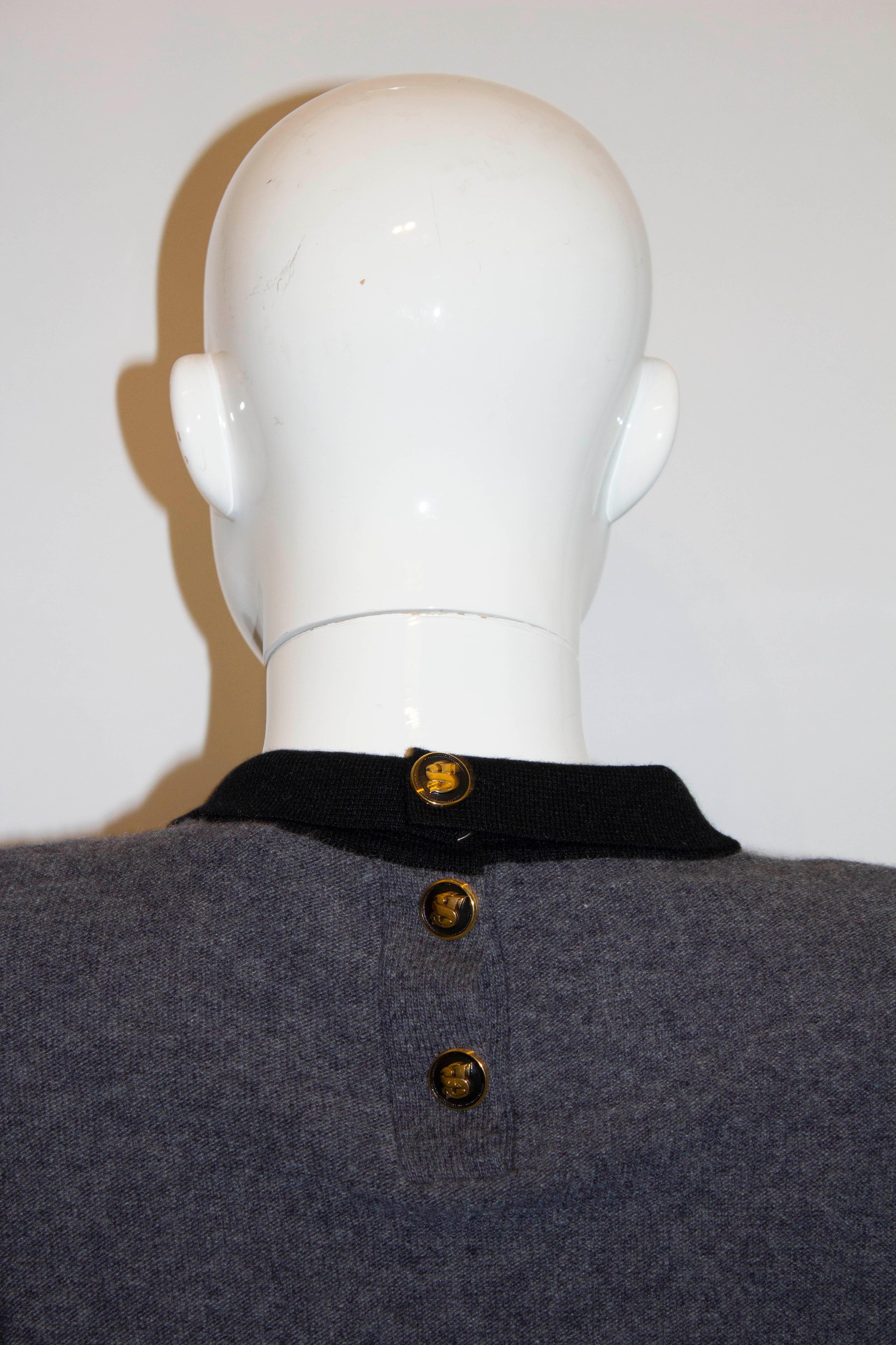 A chic vintage jumper by Sonia Rykiel for Bergdorf Goodman. The jumper is made in Italy , and has a button back opening, with a black collar and bow.  It has small knitted shoulder pads.
Size 38 Measurements: Bust up to 41'', length 21''