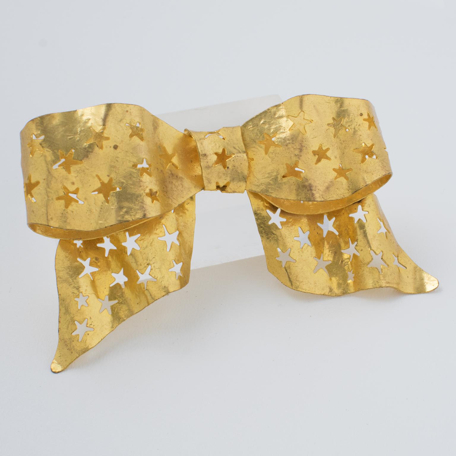 This stunning Sonia Rykiel Paris bowtie pin brooch features a dimensional massive bow shape with gilt metal all textured and with carved and see-thru stars. The piece is signed by famous French Jewel and Fashion Designer Sonia Rykiel, with a gilded
