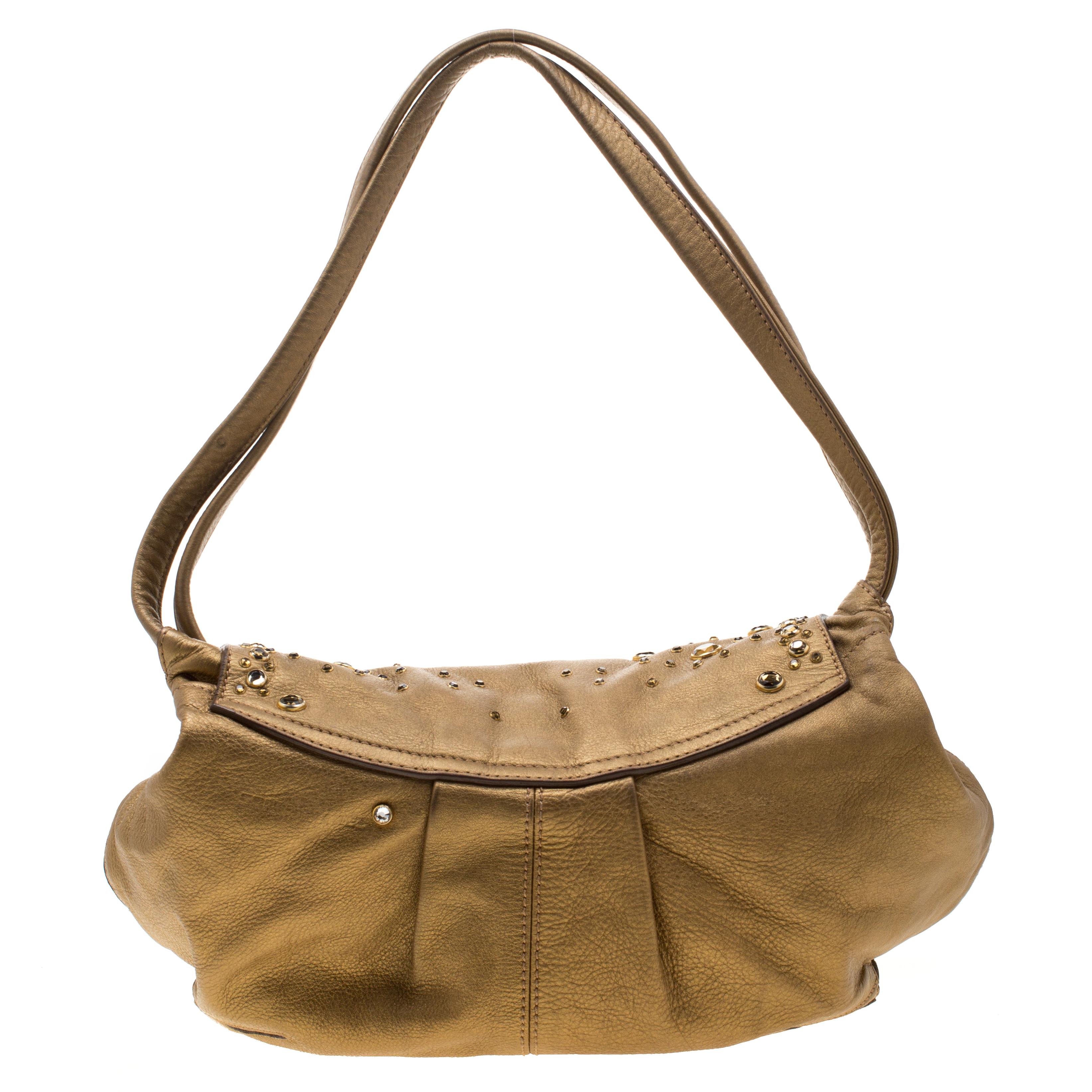 Diese schicke und feminine Tasche in Beige ist von Sonia Rykiel. Die Tasche ist aus goldfarbenem Metallic-Leder gefertigt und verfügt über eine mit Nieten besetzte Klappe, die sich zu einem mit Stoff gefütterten Innenraum öffnet, der Platz für Ihre