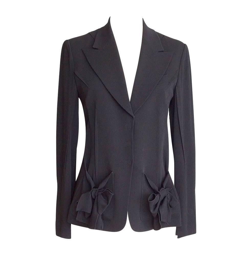 Guaranteed authentic Sonia Rykiel black pant suit.
Single breast jacket has 4 hidden front snaps and notch lapel.
Breast pocket and front stitch detail.
2 front pockets have lush bows.  SR logo plaque at edge of pocket.
Cuff has 2 working