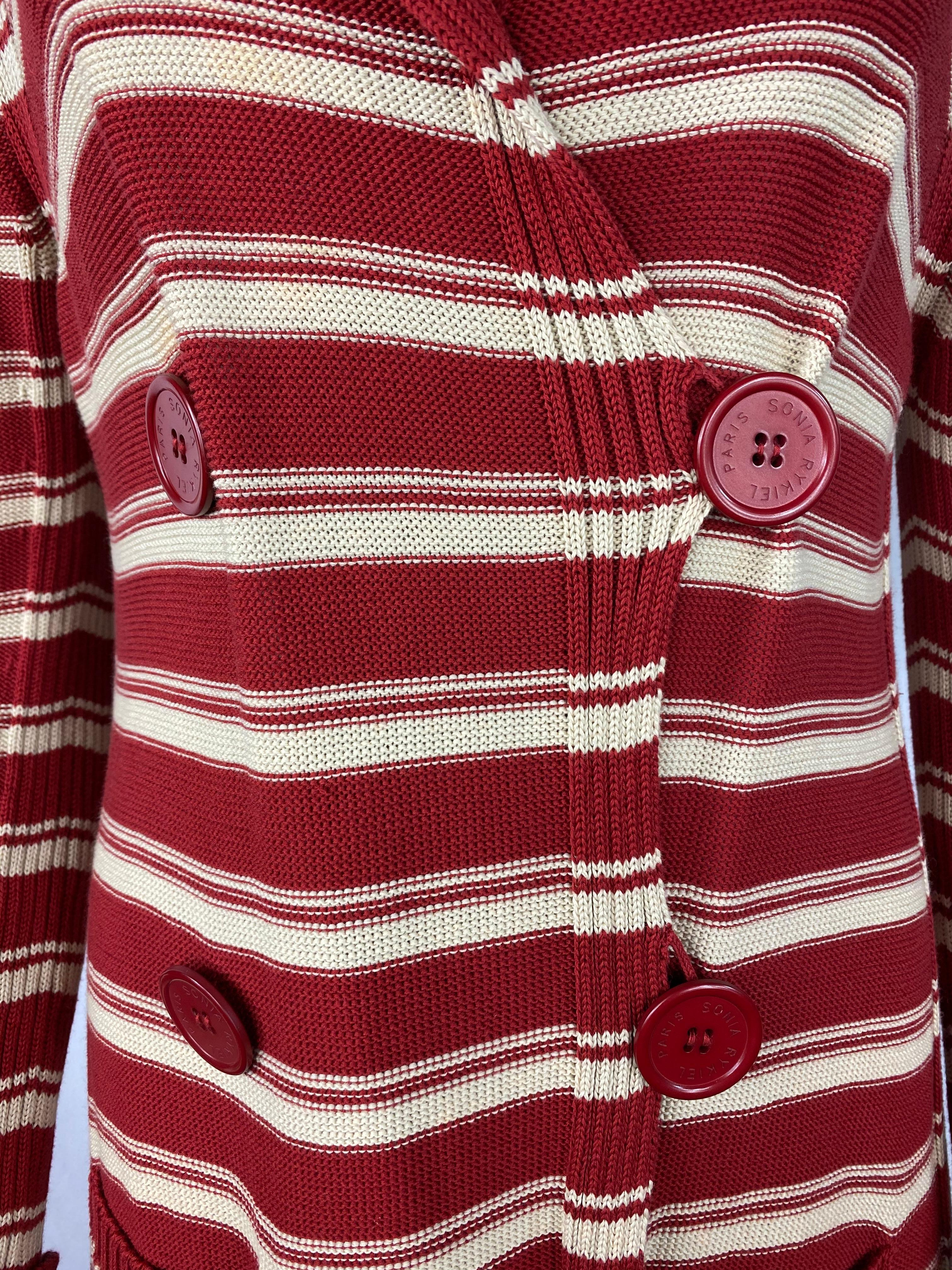 Product details:

Featuring 100% cotton, red and white stripped pattern design with collar, front dual pockets, front four large and red buttons signed with Sonia Rykiel Paris, mid length.
Made in Italy.