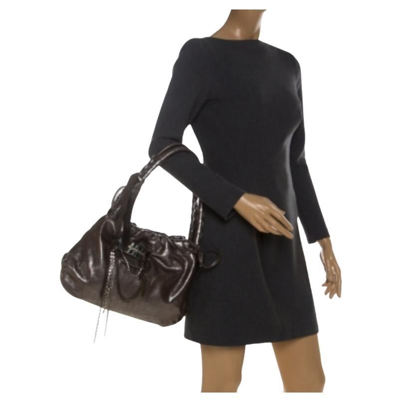 Sfoggia il tuo quoziente di moda indossando questa borsa di alta classe di Sonia Rykiel. Questa borsa in pelle è brillantemente realizzata in linea con le tendenze. Foderata in tessuto, l'interno di questa borsa è spazioso. La borsa argentata