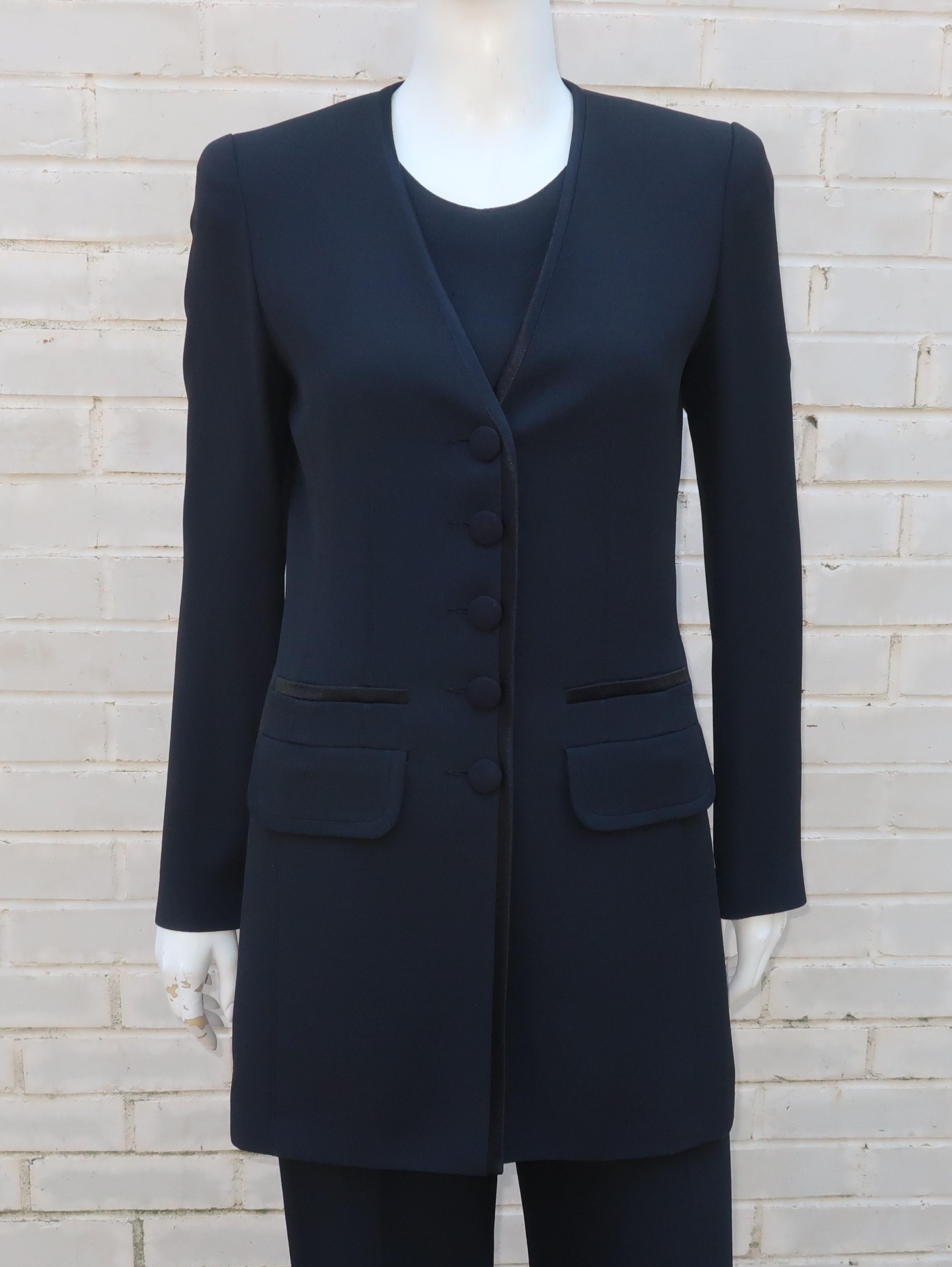 A versatile 1980's Sonia Rykiel three piece suit in a black rayon/acetate blend crepe fabric, including jacket, top and pants.  The chic details, including a satin finish to the collarless jacket, gives the ensemble a tuxedo styling which can take