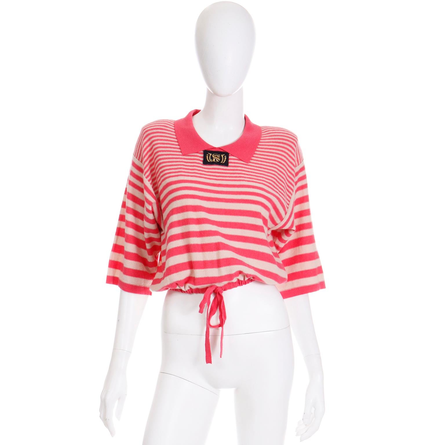 This vintage late 1980's Sonia Rykiel Paris Wool striped oversized top is in a pale beige with bright pink horizontal stripes and a drawstring waist. This fabulous knit top has shoulder pads, 3/4 length sleeves, upper back buttons and a pointed pink