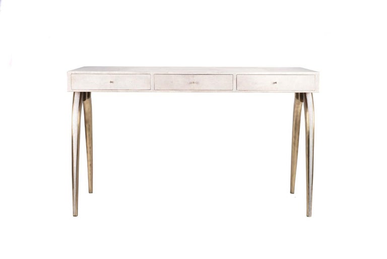 The Sonia writing desk is the perfect piece for your room. A more subtle version to her sister the iconic writing desk, the Sonia has elegant legs inlaid in shagreen and bronze-patina brass. Add a mirror and this desk becomes a vanity table. This
