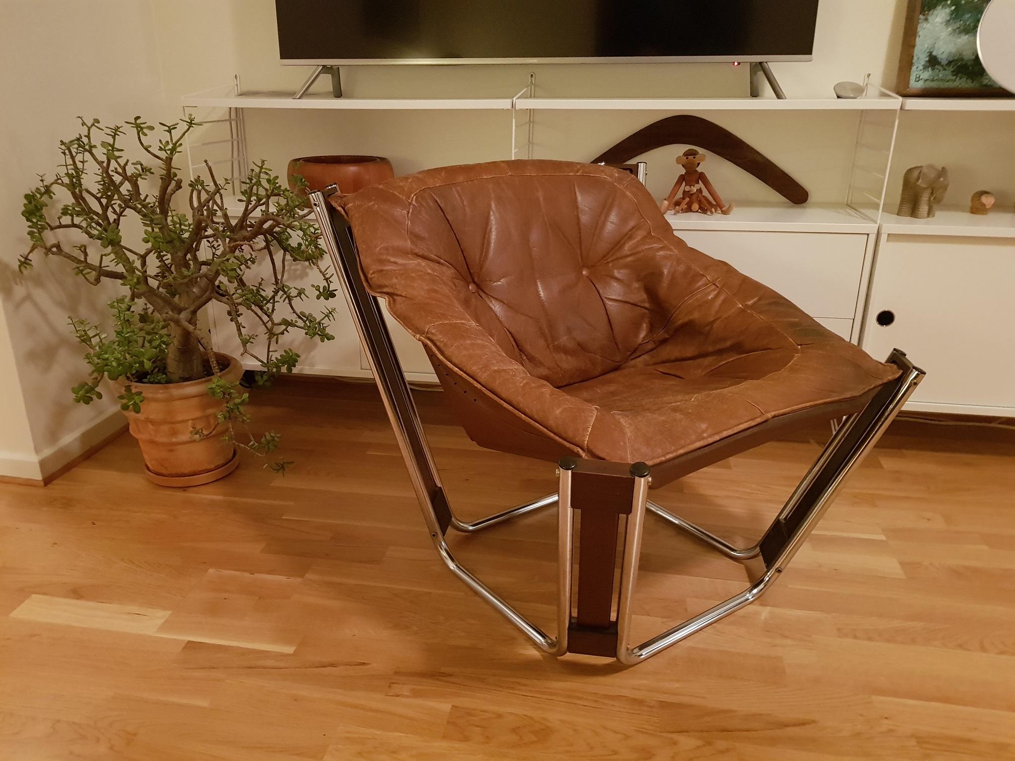 1 vintage lounge chair in brown leather and chromed base designed and produced in the 1970s. Great looking patina. Design by the Norwegian designer Odd Knutsen and made in Norway by Hjellegjerde in the 1970s. This is a furniture that inspires and