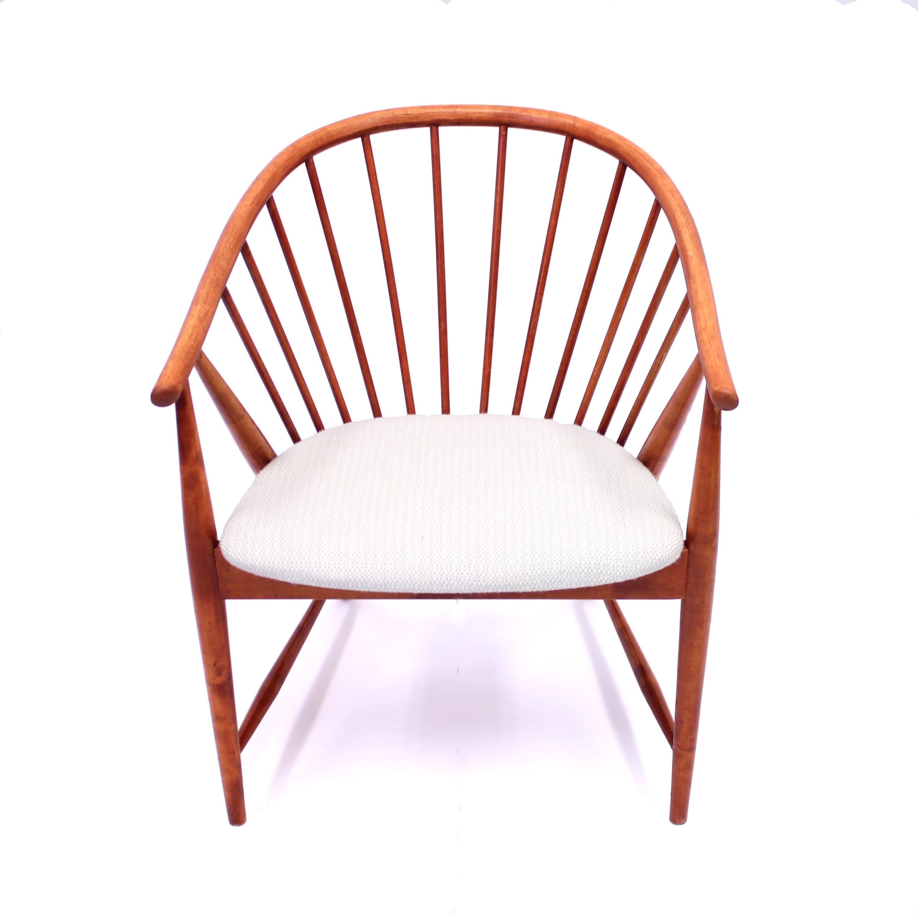 Sonna Rosén, Solfjädern (meaning Sun feather) armchair in red/orange stained birch made by Swedish manufacturer Nässjö Stolfabrik (also called NESTO), 1950s. Newly upholstered seat with white/beige fabric. The round bar backrest has been restored