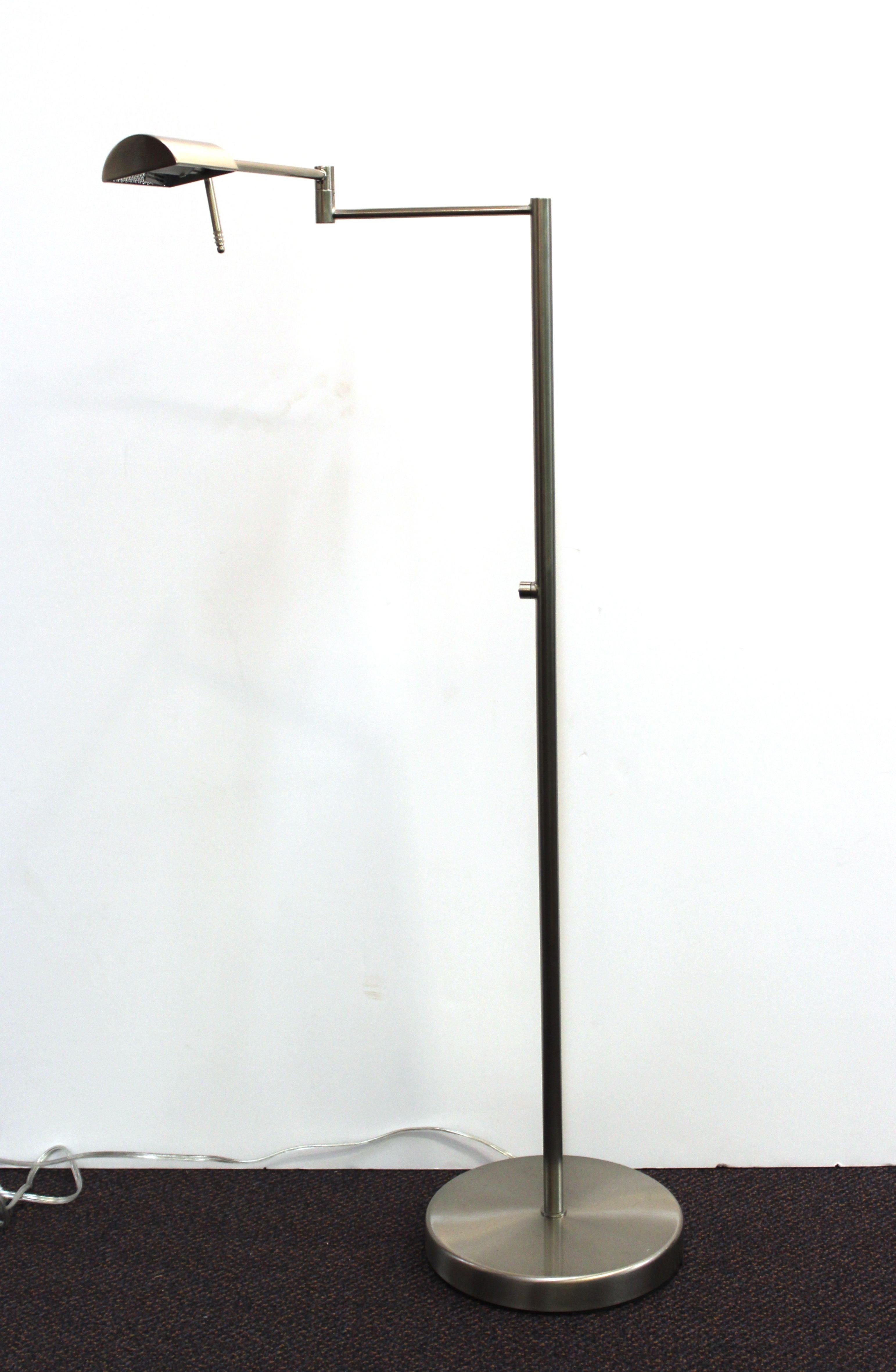 Modern Minimalist pair of floor lamps or reading lamps in metal, both with adjustable arms and heads, made by Sonneman. The pair is in great vintage condition, with one of the lamps missing the glass cover for the bulb.