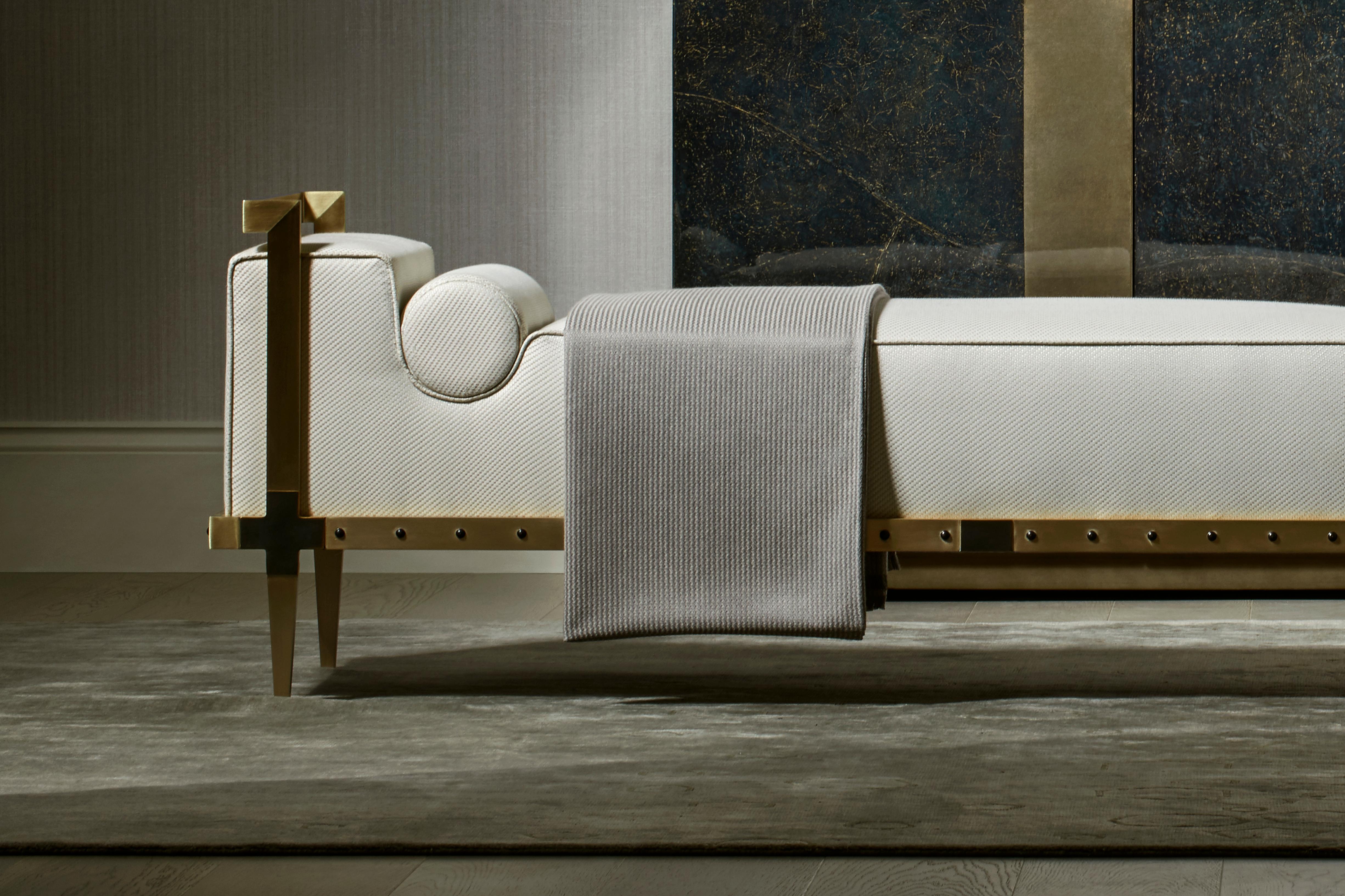 A contemporary yet timeless tribute to the ‘love seat’, the design is upholstered in a tailored fabric with hand piping to enhance the silhouette. 

The striking solid brushed brass and bronze frame is finished with an elegant studded detail.