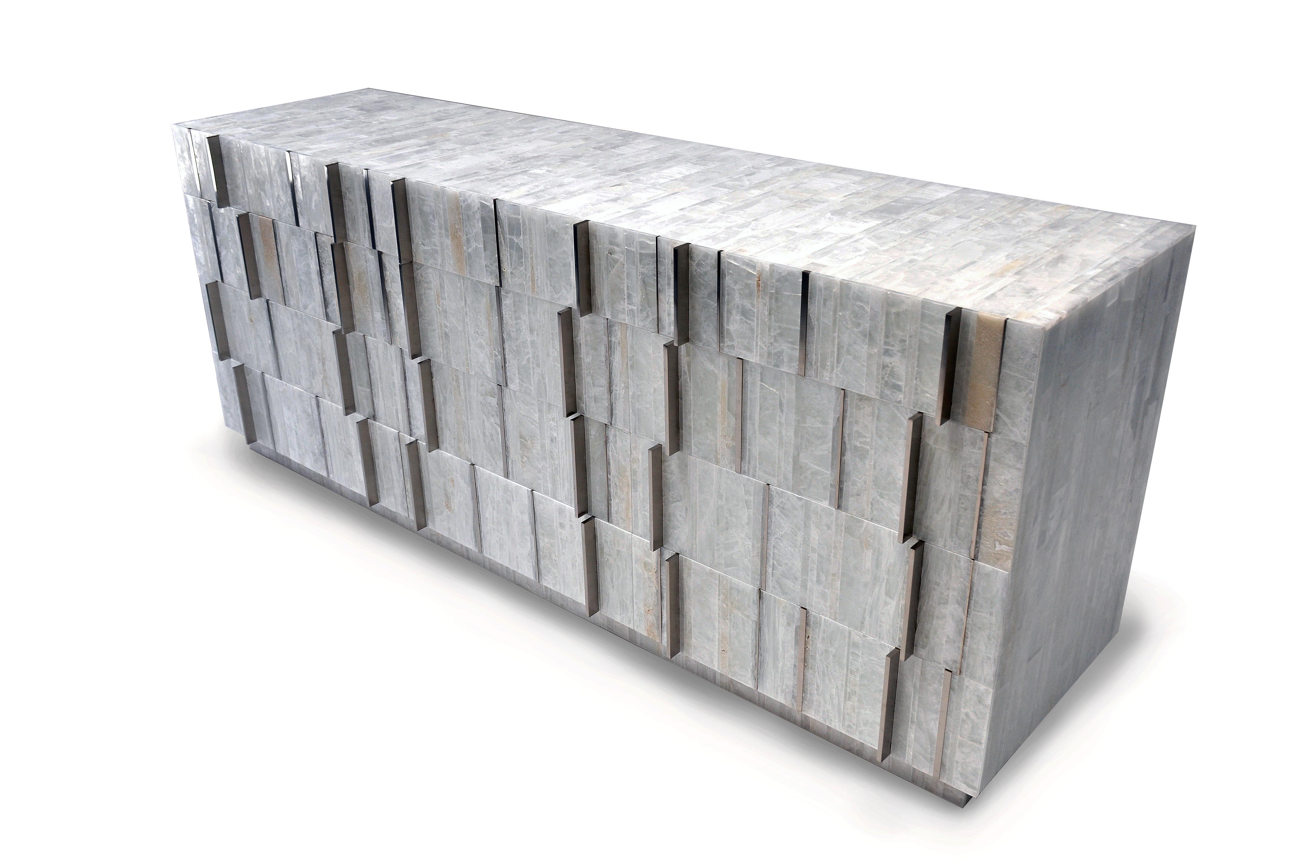 The Sonnet dresser uses the rhythmic patterns of selenite, hand cut and arranged in vertical pattern along with polished metal inlay and handles to create a beautiful luxurious statement piece. Selenite is a naturally occurring crystalline form of