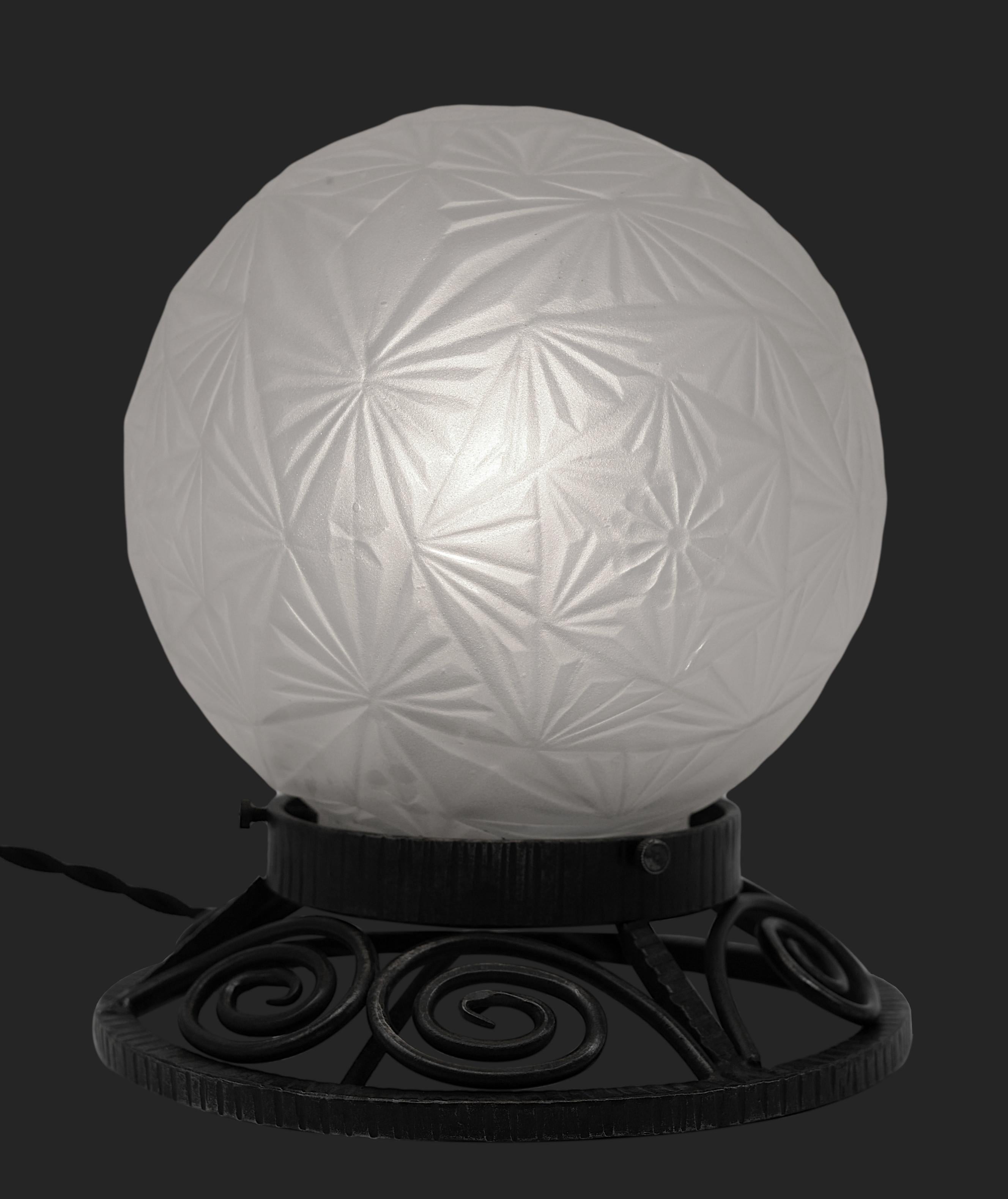 French Art Deco table lamp by Societe Normande de Verreries Sonover, 11 rue Nationale, Aumale, France. Frosted glass shade on its wrought-iron base. Floral decor. Height: 6.7