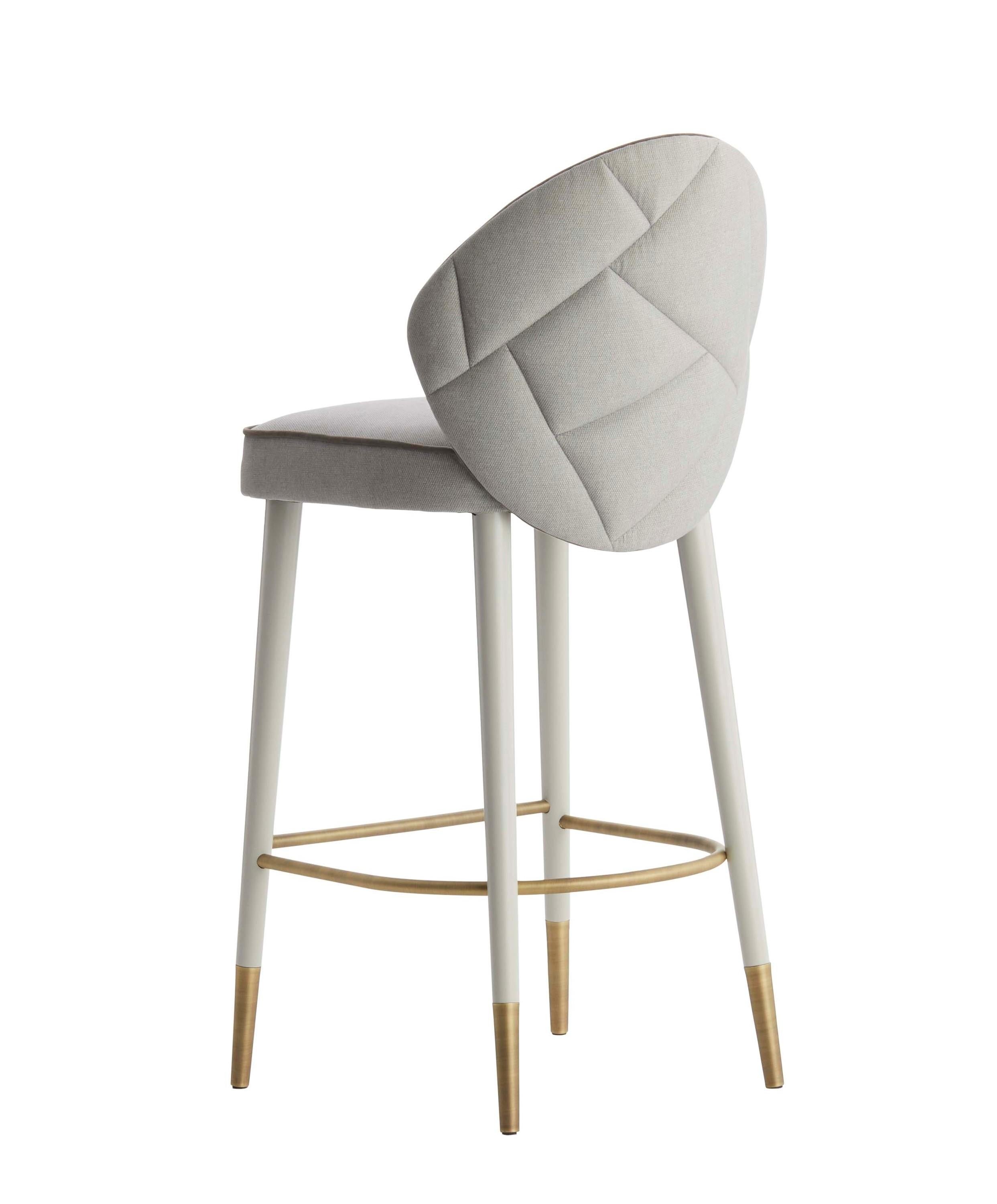Elegant and comfortable, SOPHIA is a high stool with a special quilted details on the back.‎ Perfect from every angle, this stool is upholstered in fabric, while the lacquered legs are enriched by antique brass feet.‎ Sophia is also available in
