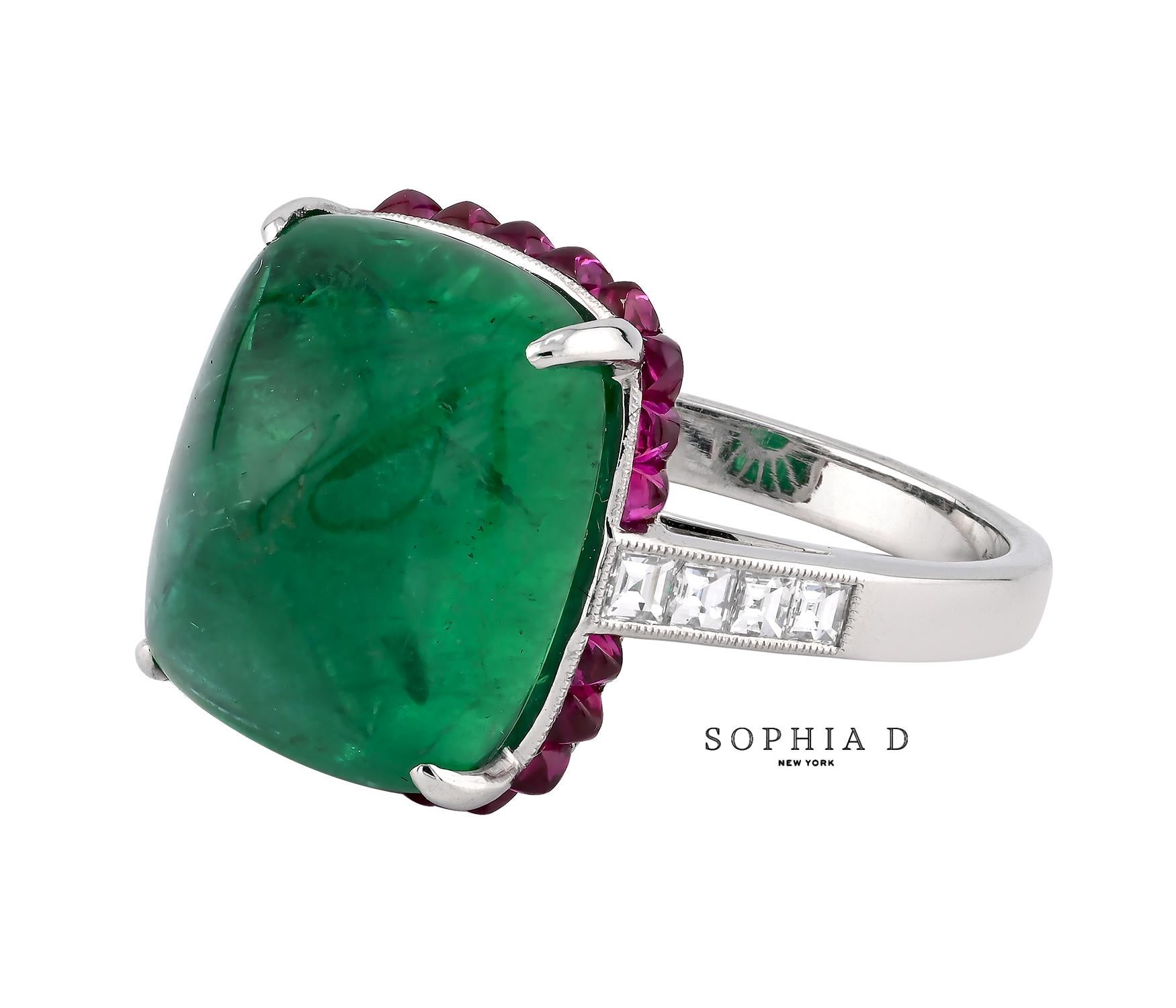 Dieser Ring ist mit einem 10,94 Karat schweren Smaragd-Cabochon besetzt, der sich durch seine tiefgrüne Farbe und seine glatte Oberfläche auszeichnet. Der Smaragd ist von einem Halo aus Rubinen von insgesamt 0,95 Karat umgeben, der seinen satten